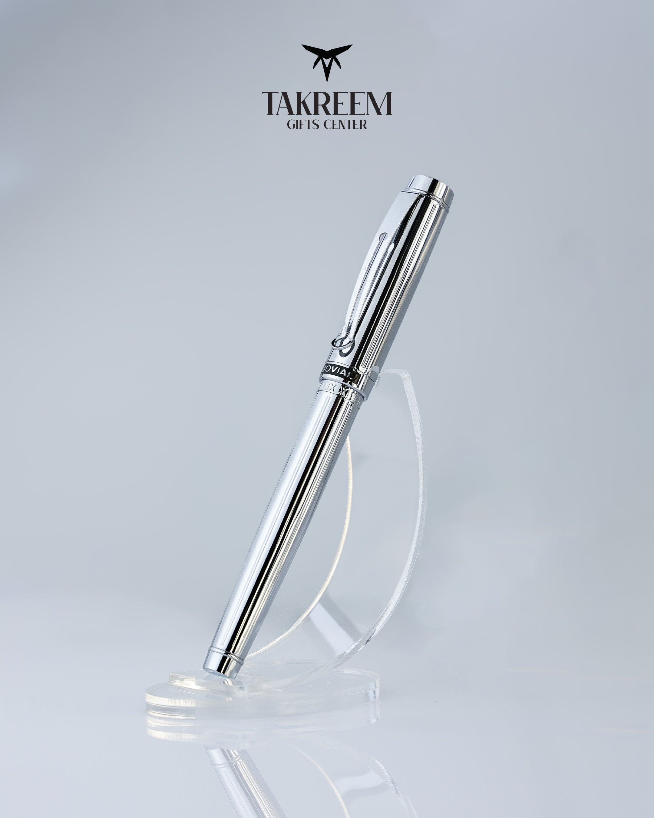 Silver pen on a clear stand with 'Takreem Gifts Center' logo above on a light gray background