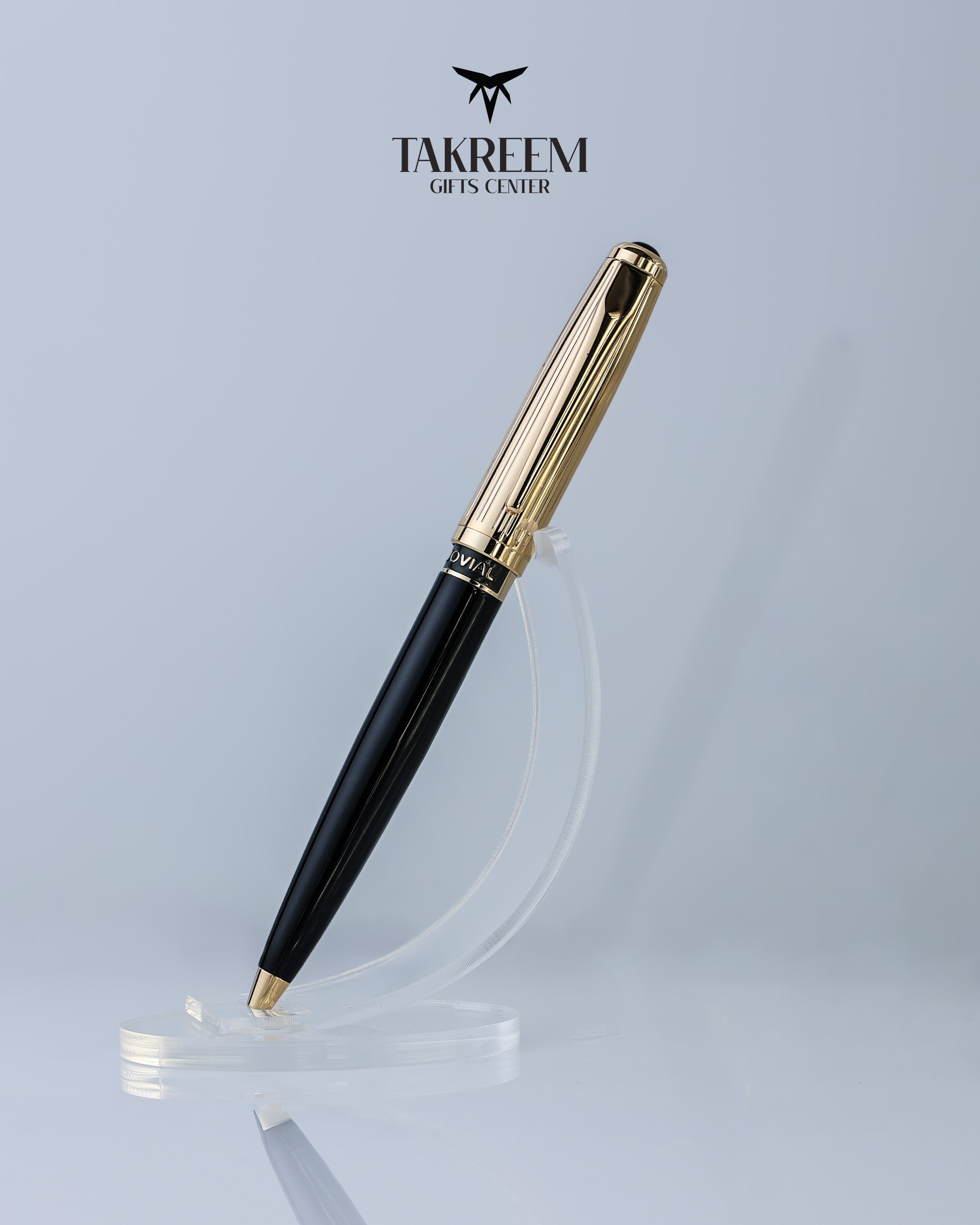 Black and gold pen on a clear stand with 'Takreem Gifts Center' branding.
