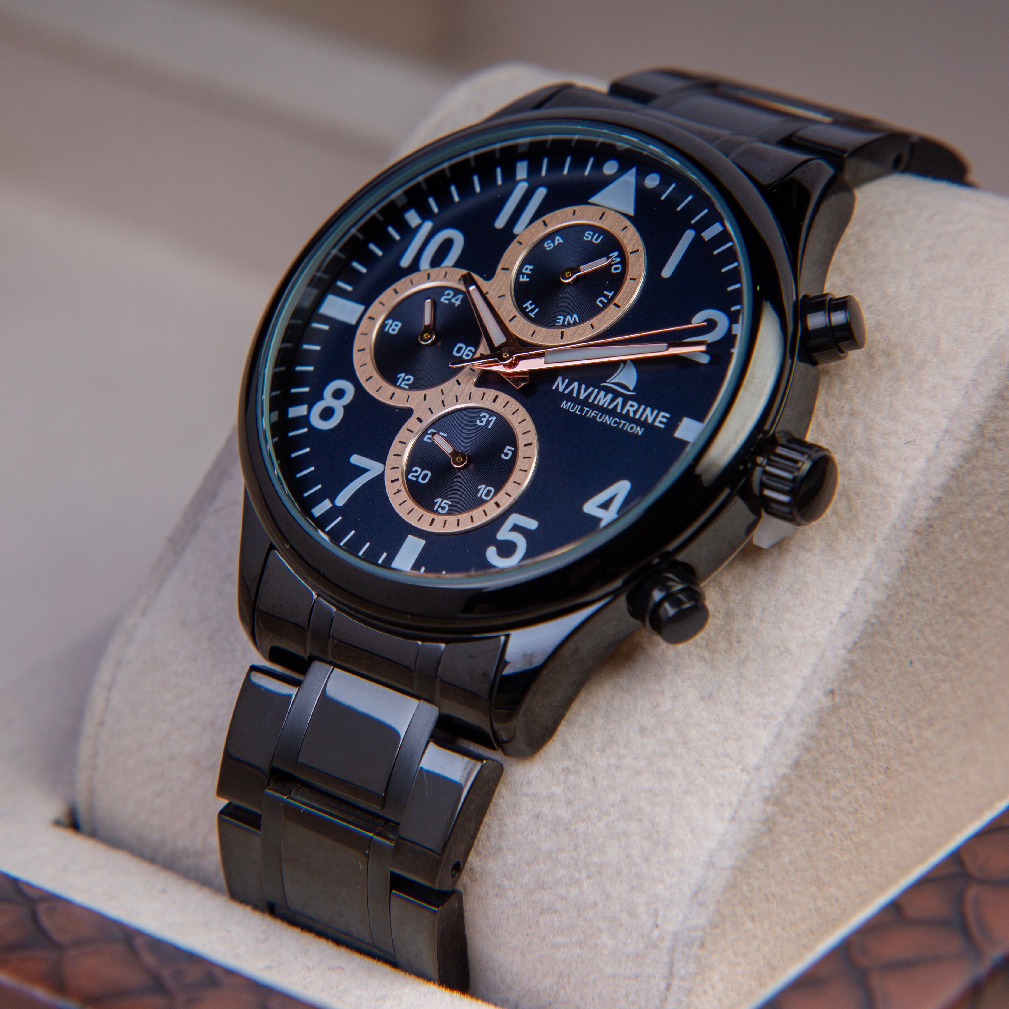 Black wristwatch with blue dial on a textured surface