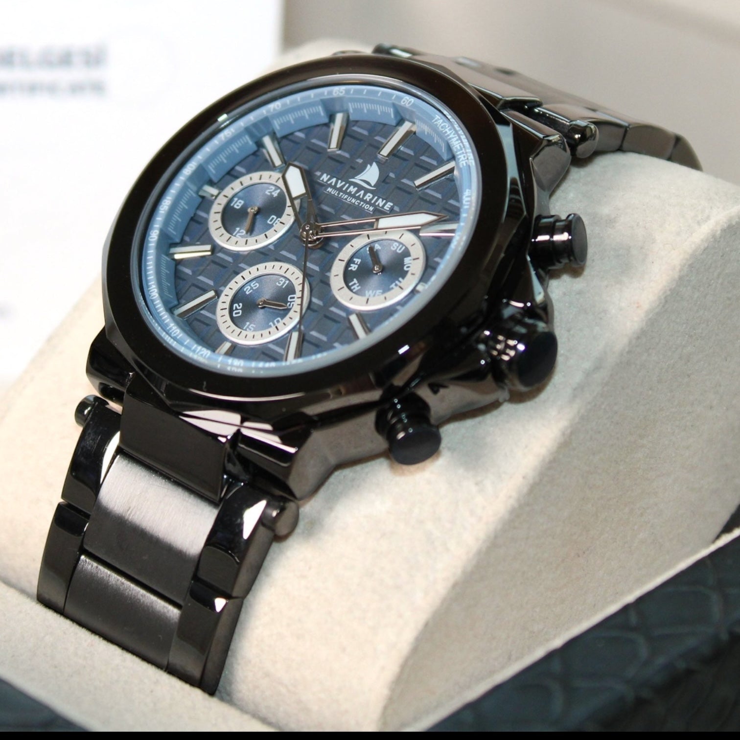 Black wristwatch with a detailed face on a white cushion