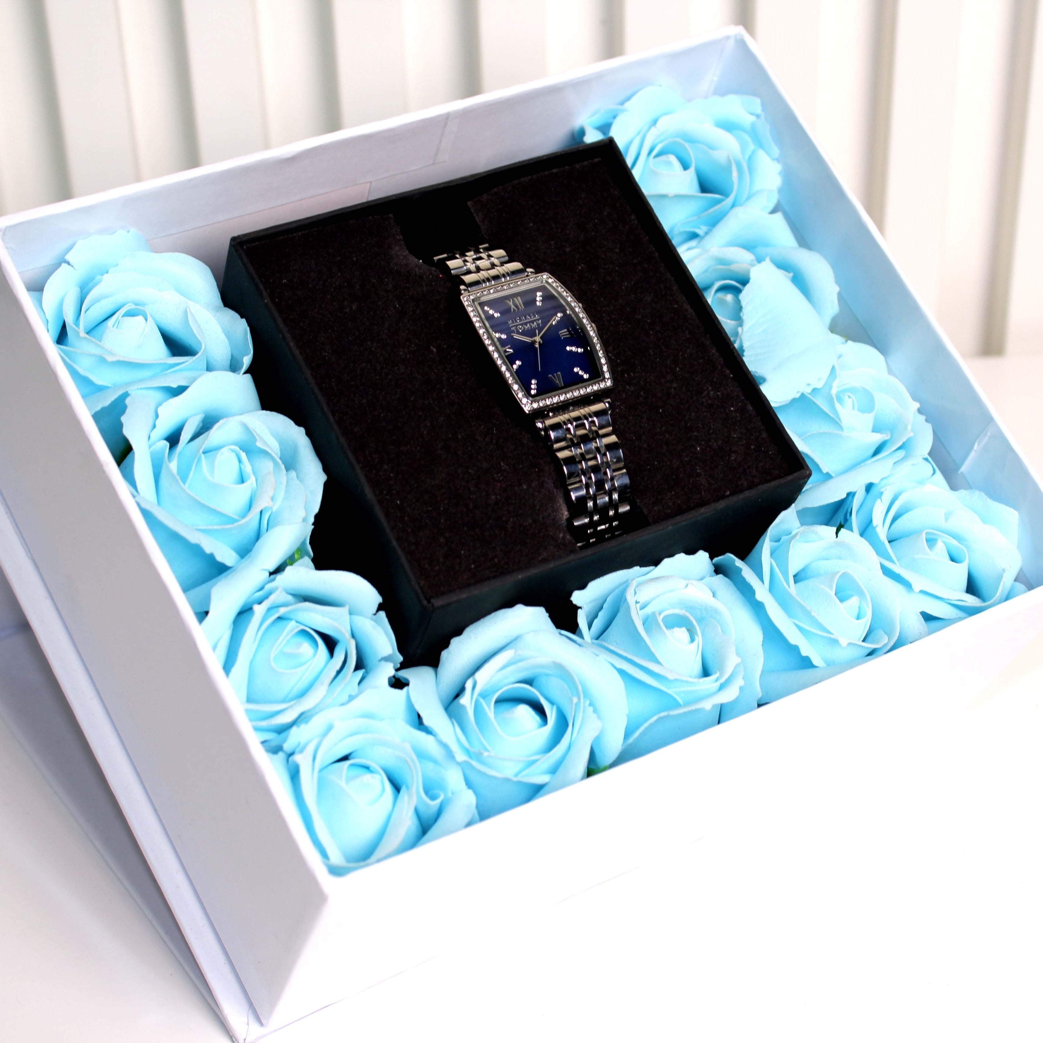 Black jewelry box with a blue rose arrangement in a white box