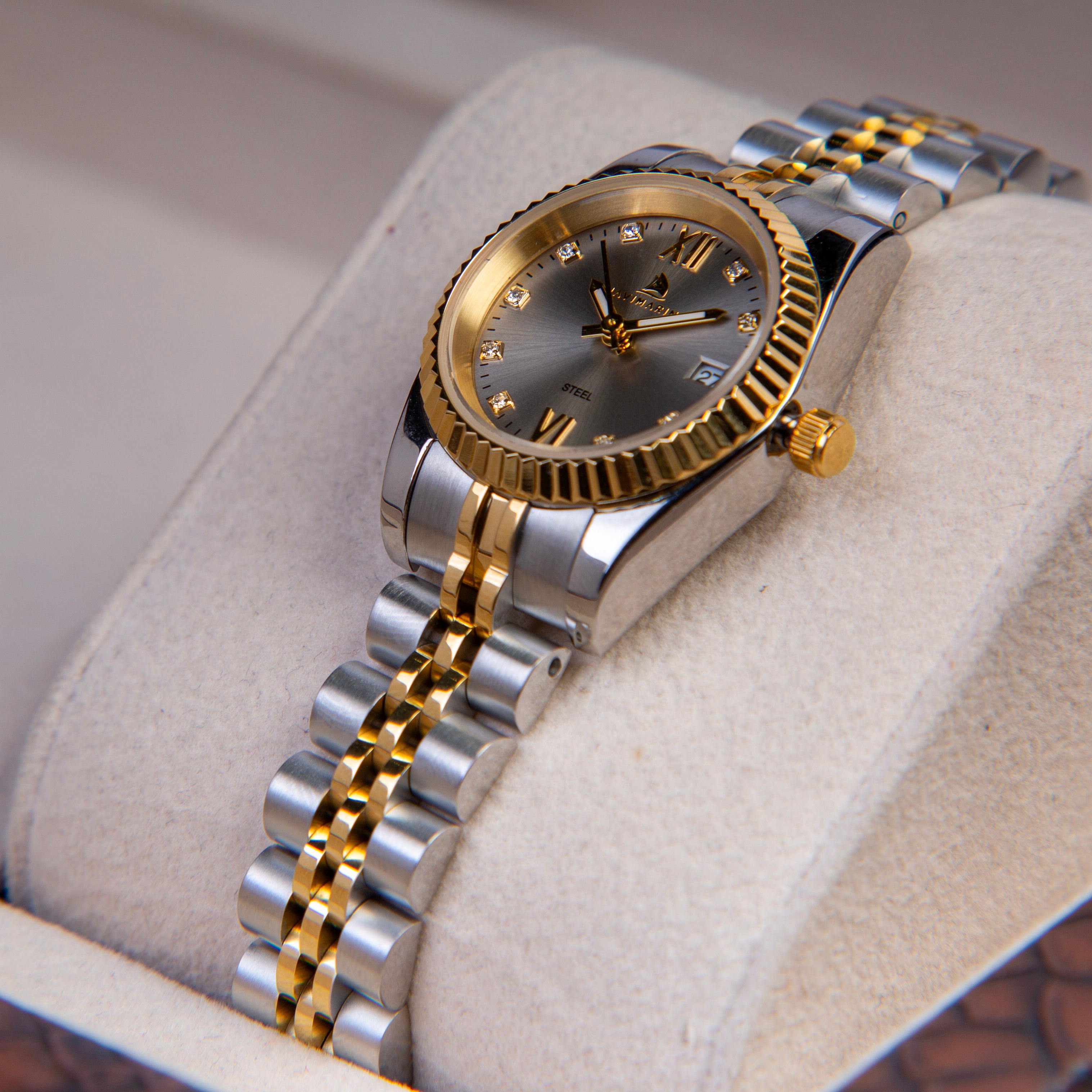Two-tone silver and gold watch on a textured surface