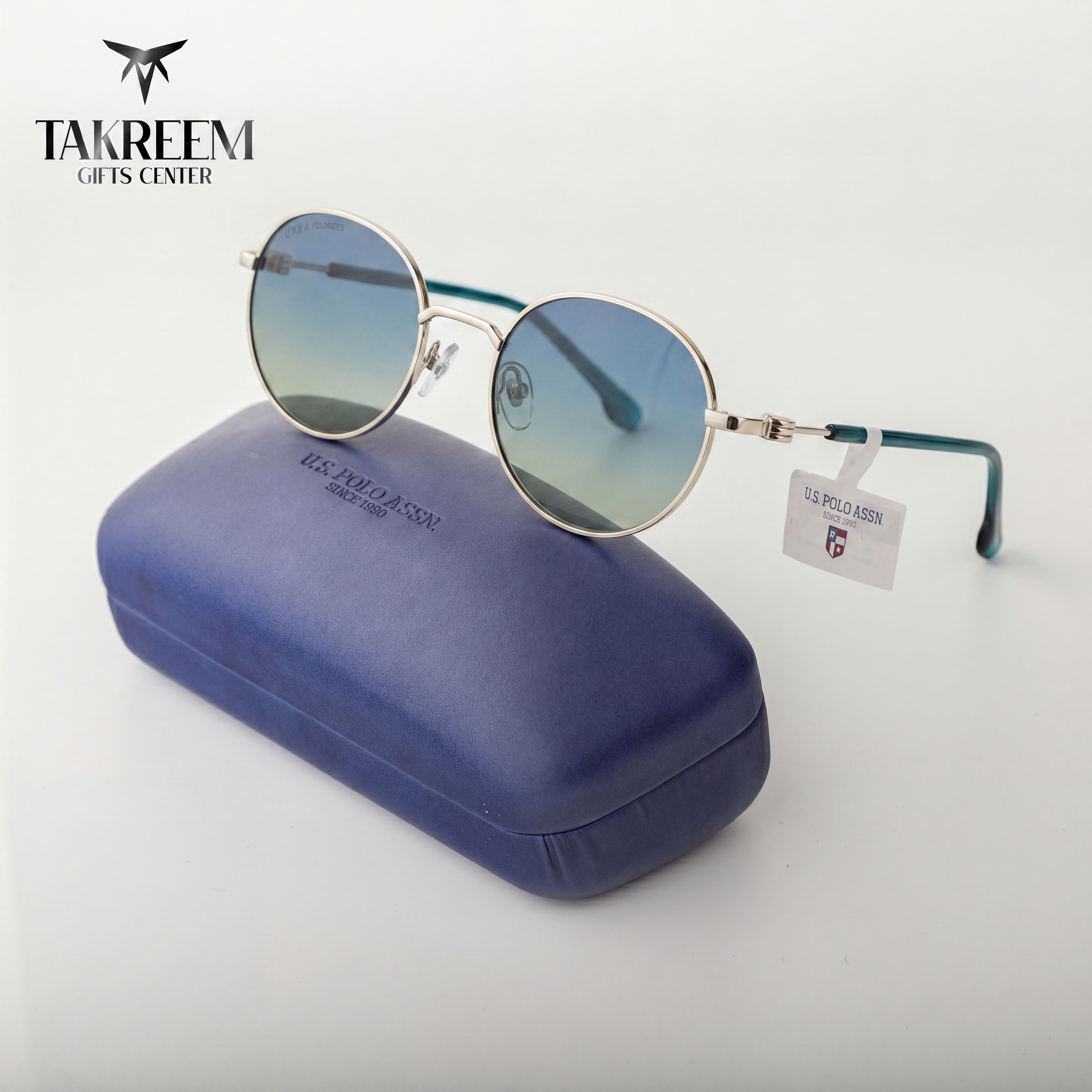 Sunglasses with a U.S. Polo Assn. tag on a blue case, branded 'Takreem Gifts Center'.
