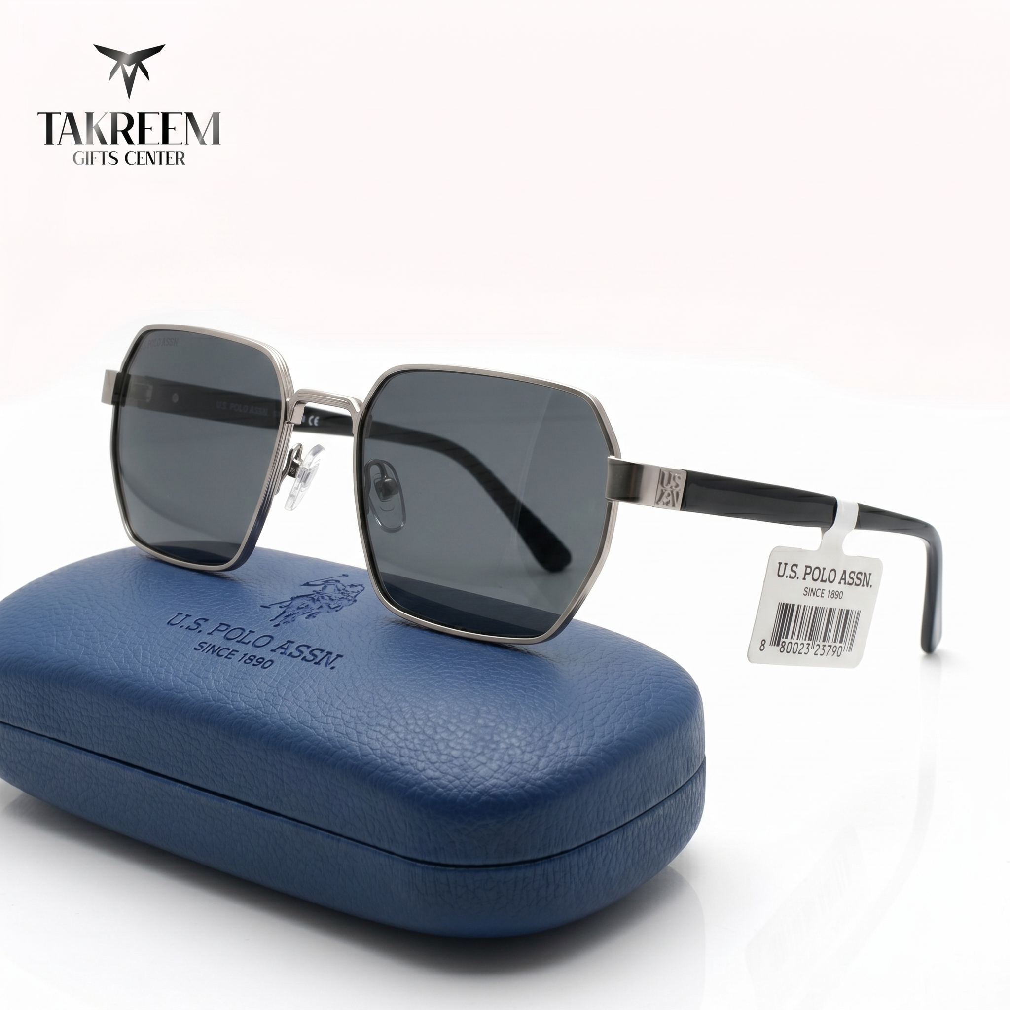 Sunglasses with a blue case and U.S. Polo Assn. tag on a white background, featuring Takreem Gifts Center branding.