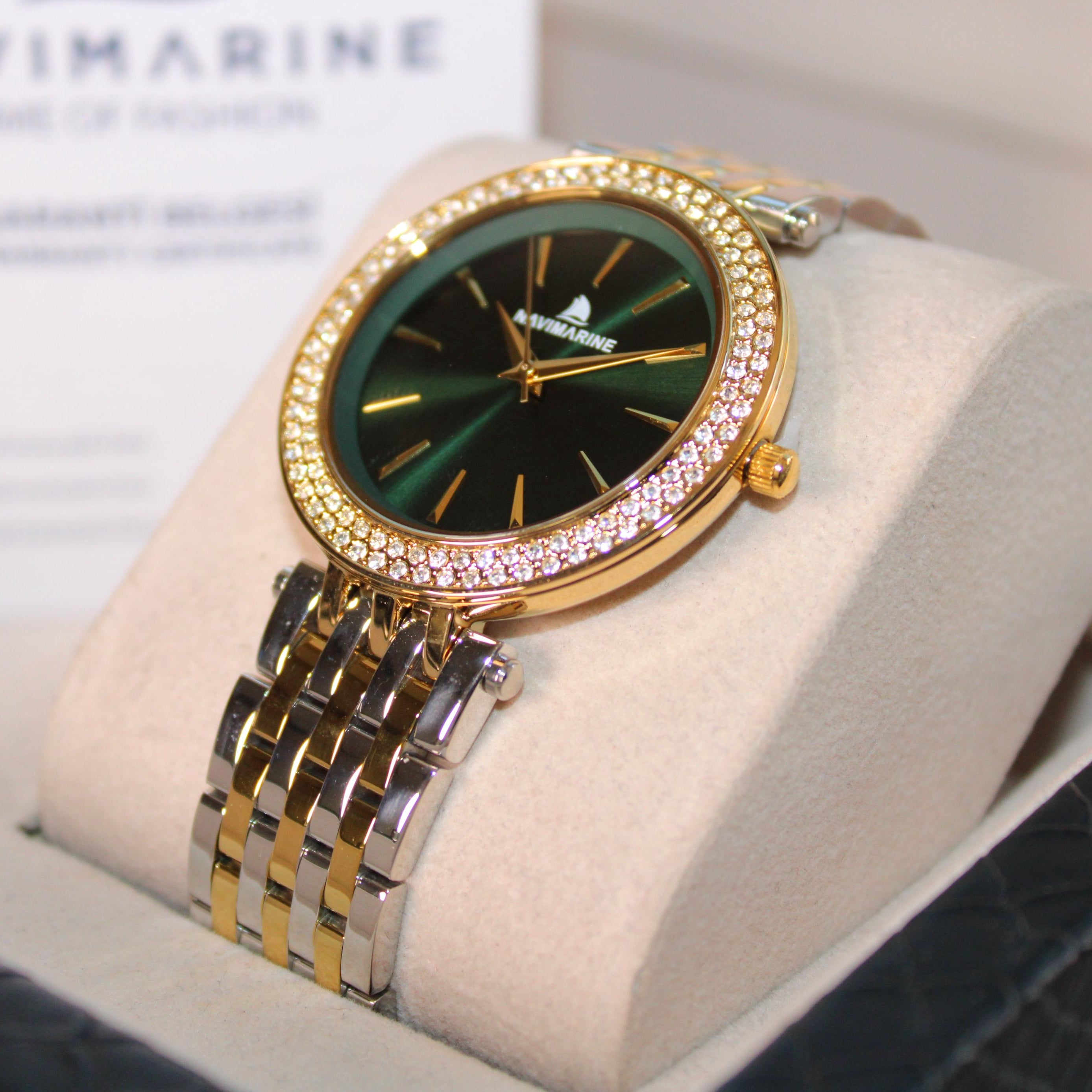 Luxury watch with gold and silver band on a display stand, branded 'Navimagine'.