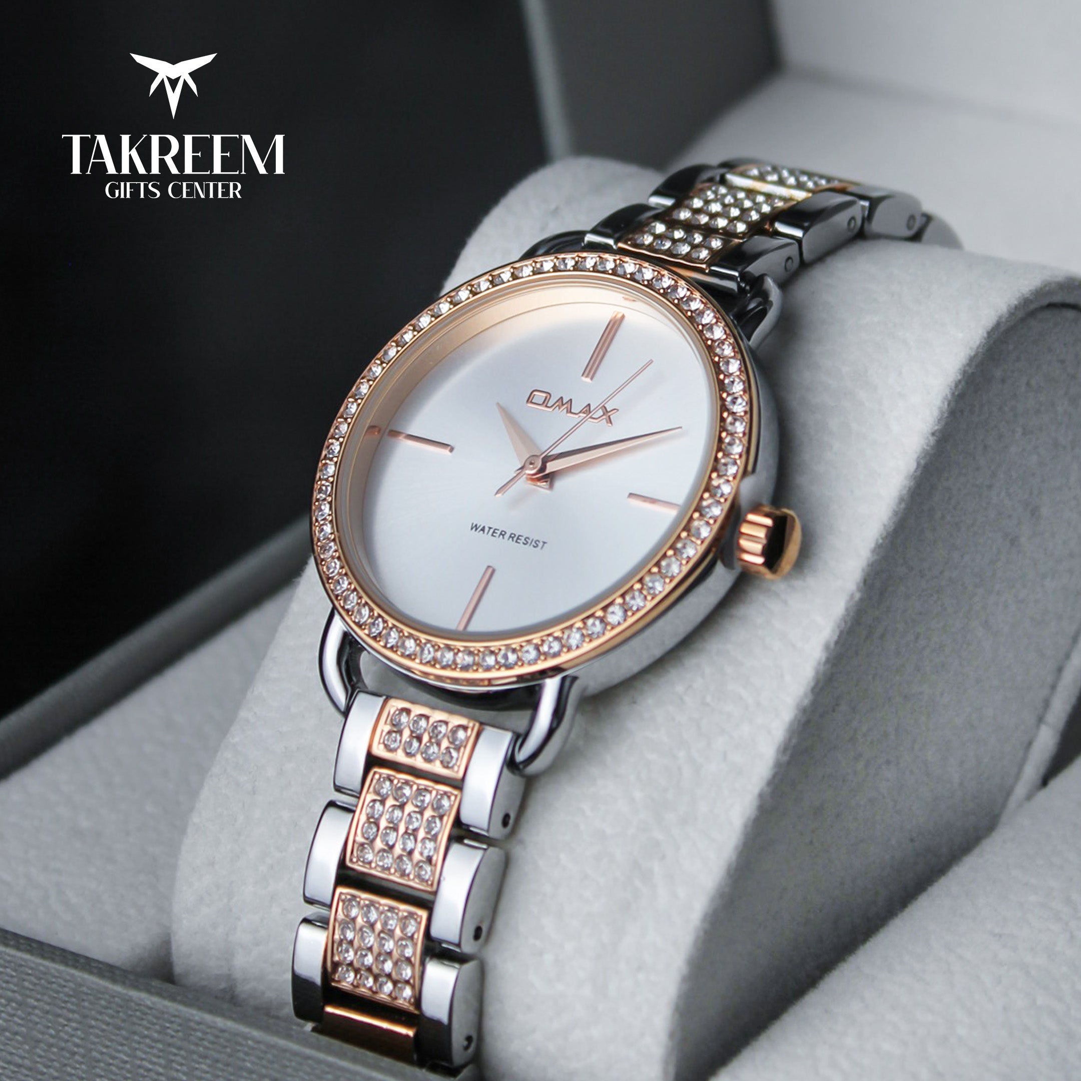 Luxury watch with rose gold and silver band on a gray cushion, brand 'Takreem' visible.