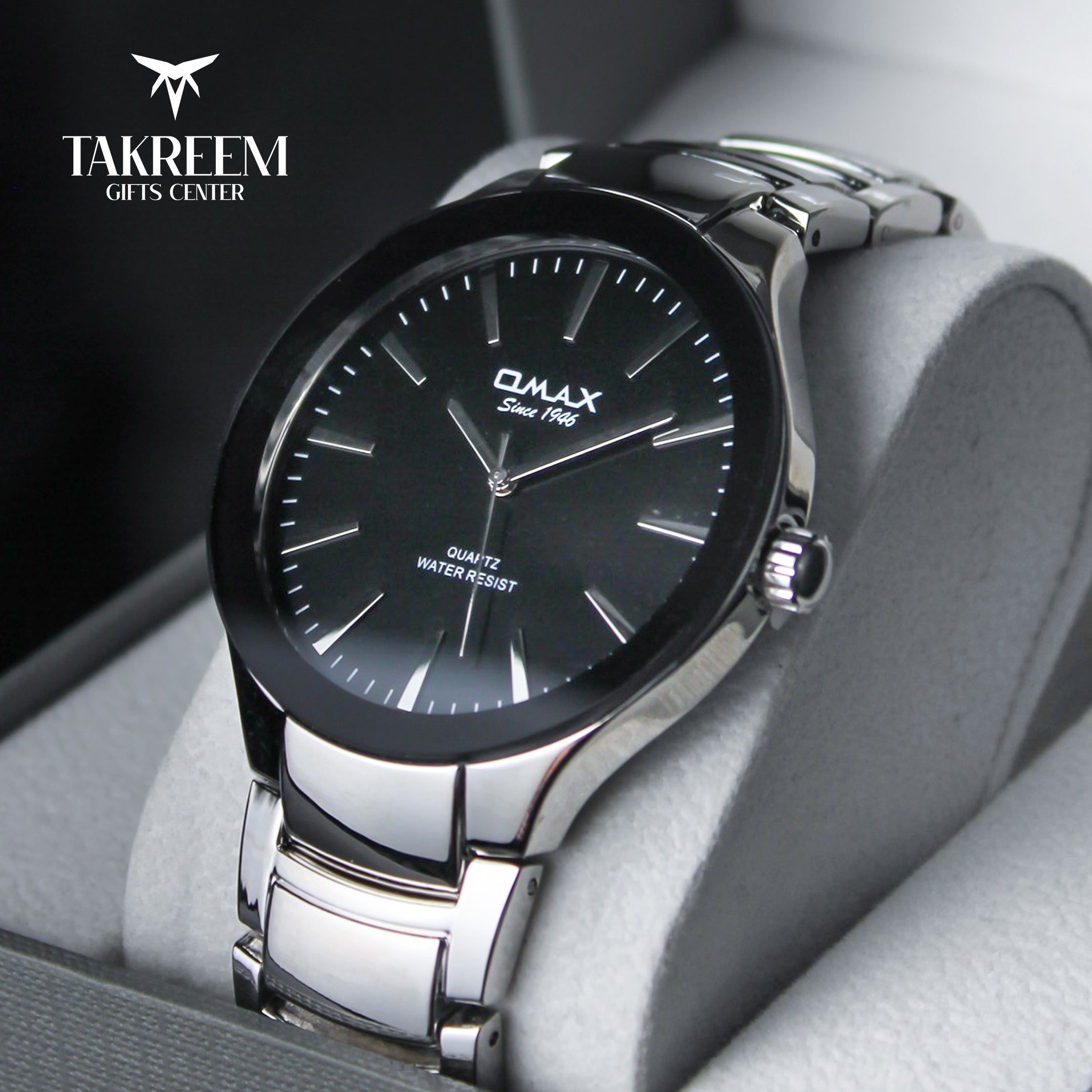 Black watch with silver strap on a gray surface, featuring the brand 'Takreem'.