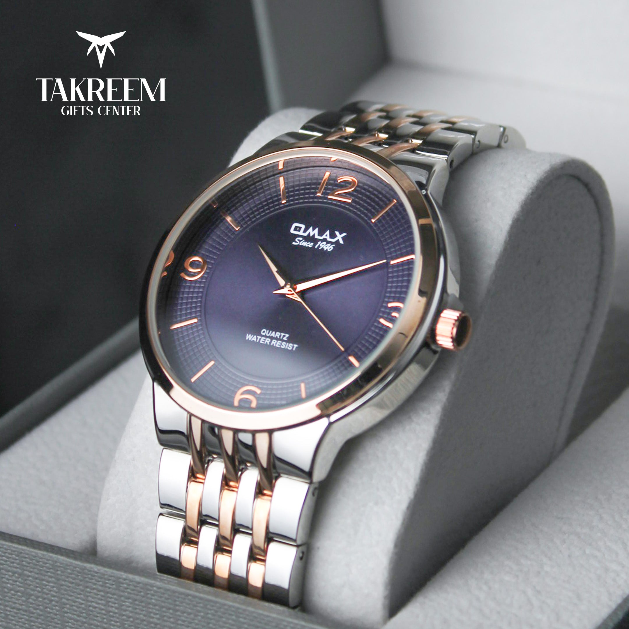 Luxury watch with blue dial and rose gold accents in a gray box, branded 'Takreem Gifts Center'.