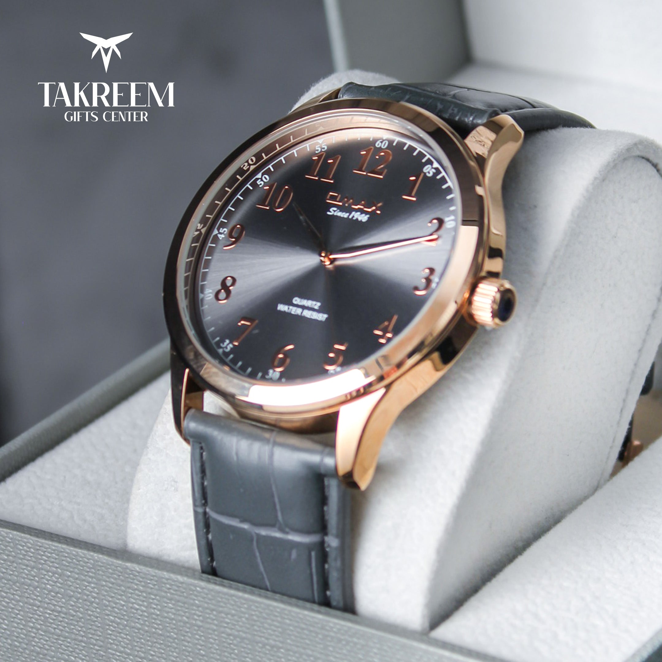 Luxury watch with rose gold case and black strap in a box, brand 'Takreem' visible.