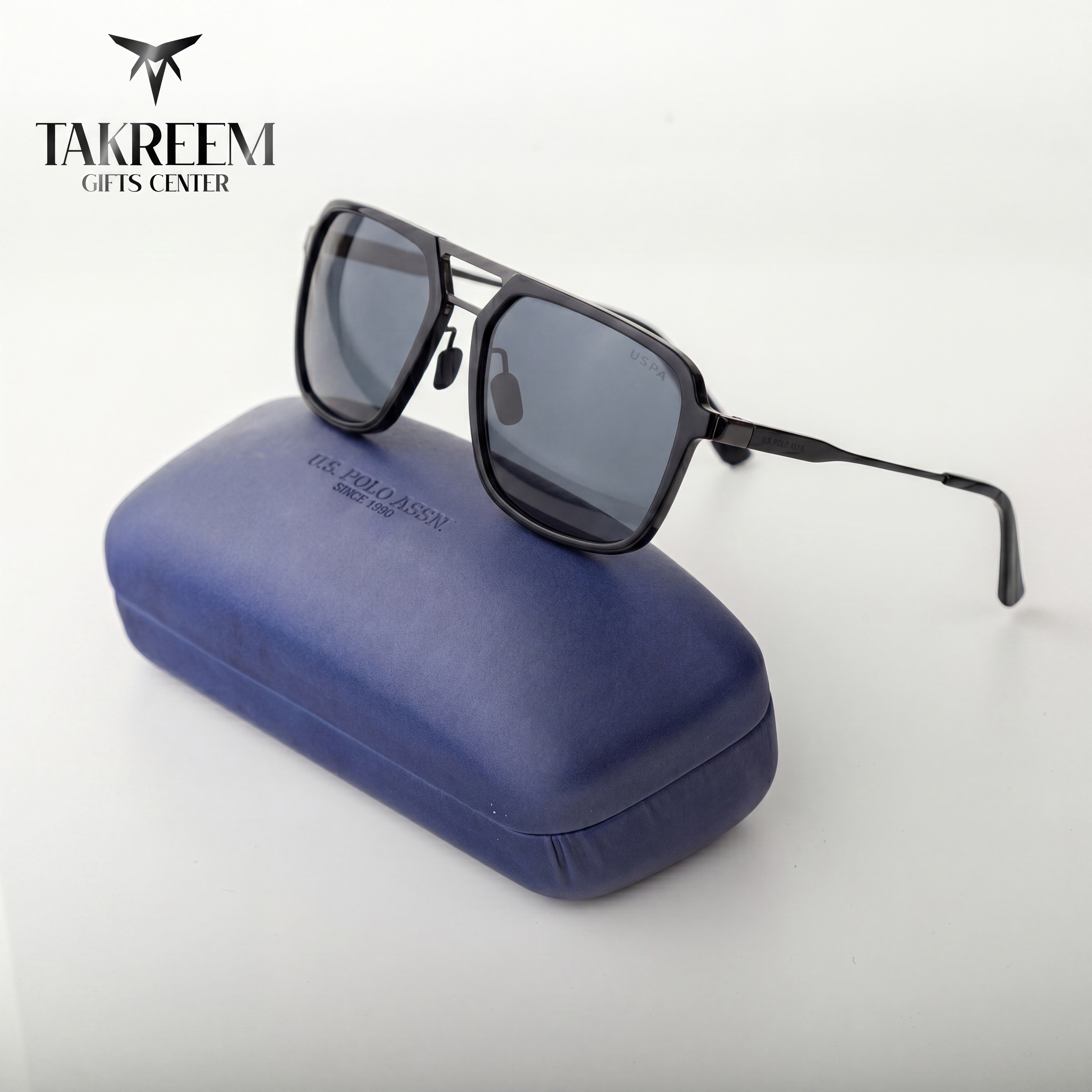 Sunglasses with a blue case on a white background, featuring the Takreem Gifts Center logo.