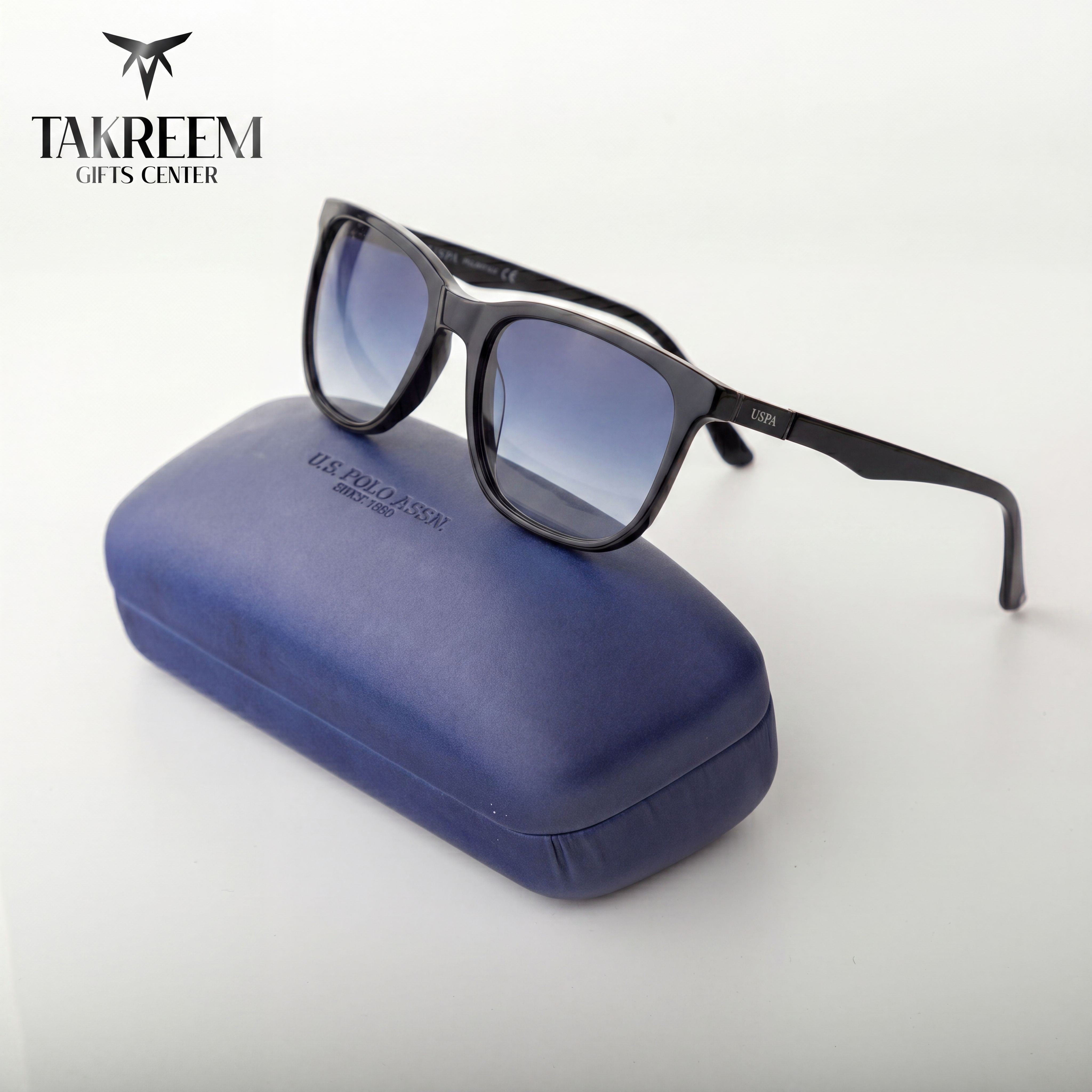 Sunglasses with a blue case on a white background, featuring the Takreem Gifts Center logo.