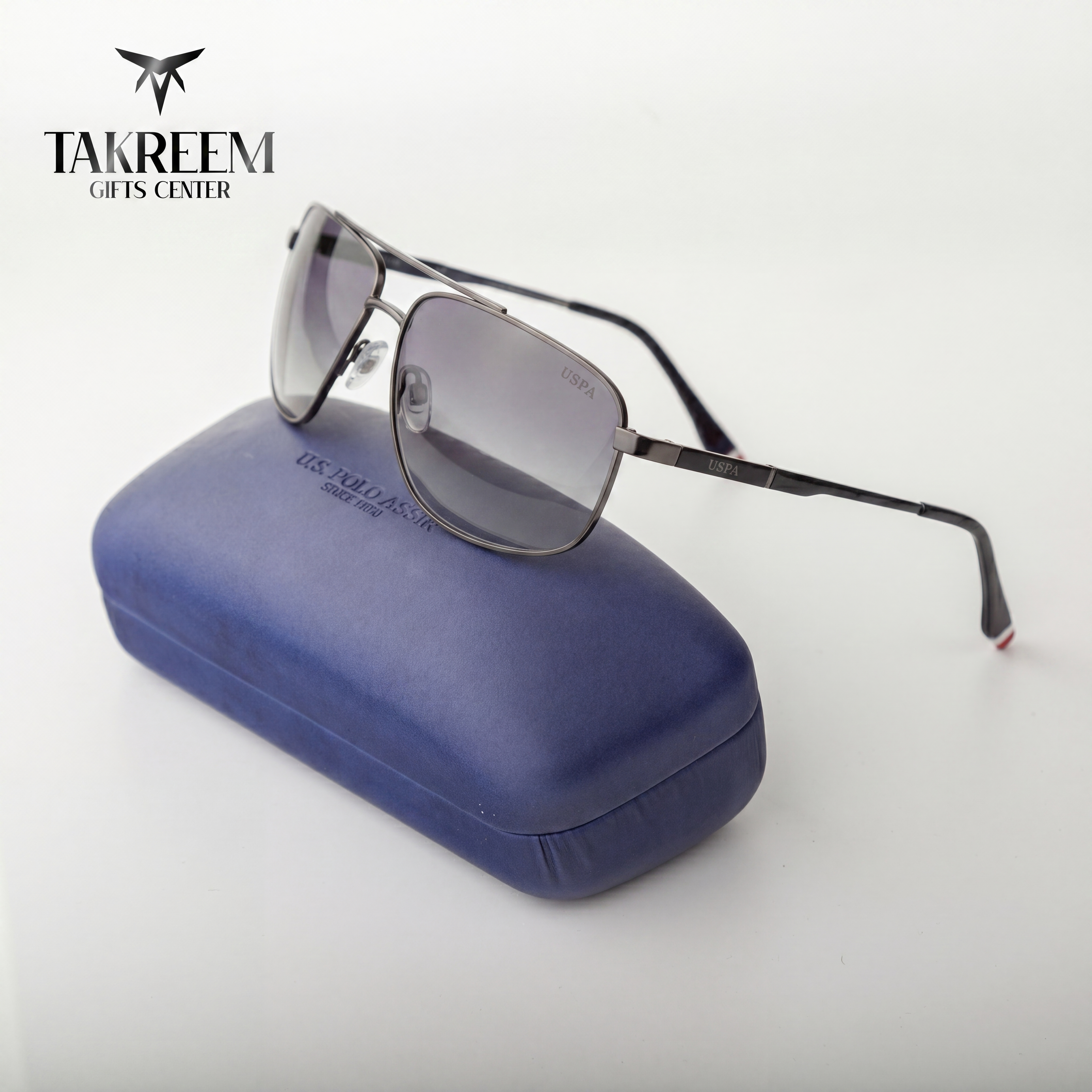 Sunglasses on a blue case with 'Takreem Gifts Center' branding.