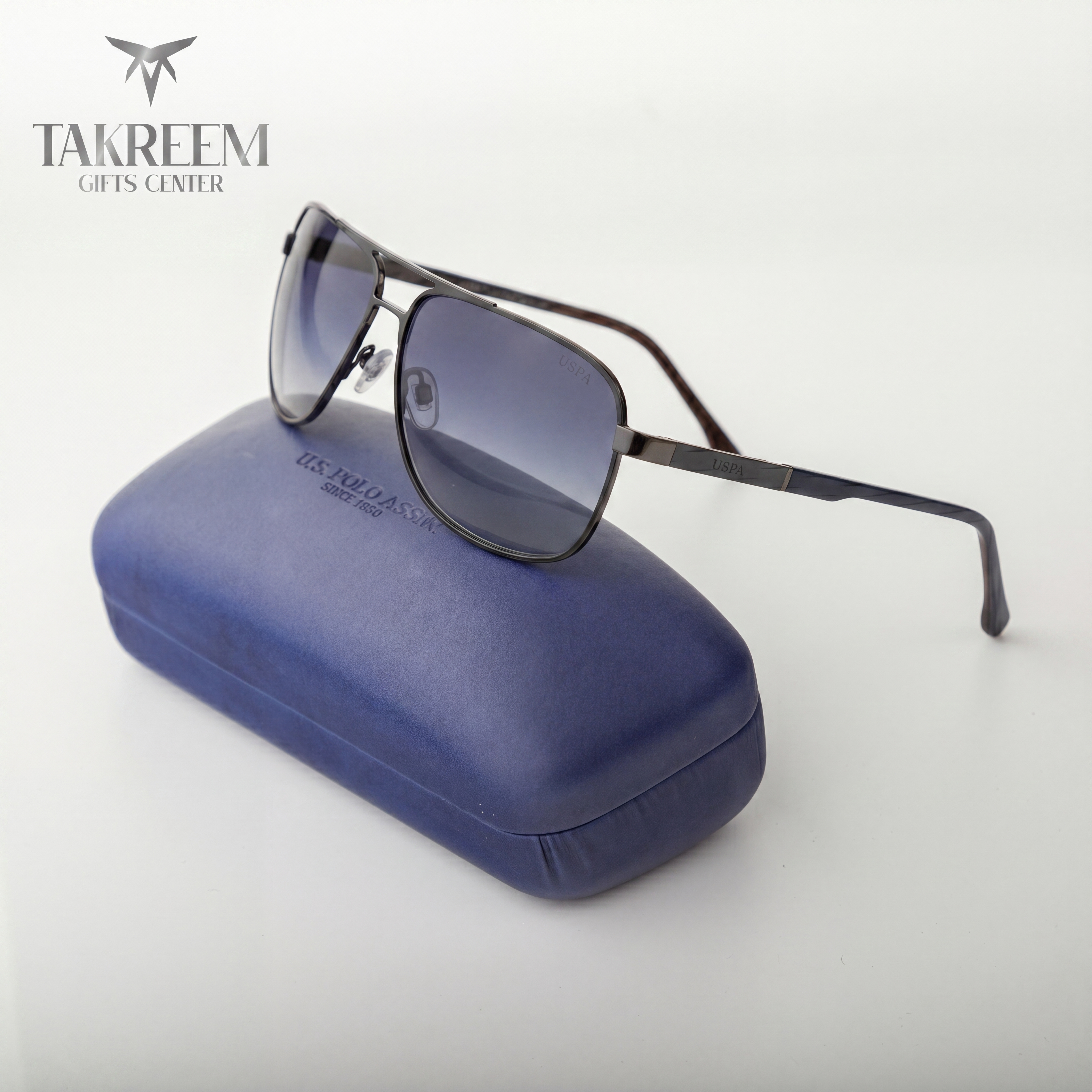Sunglasses on a blue case with 'Takreem Gifts Center' branding.