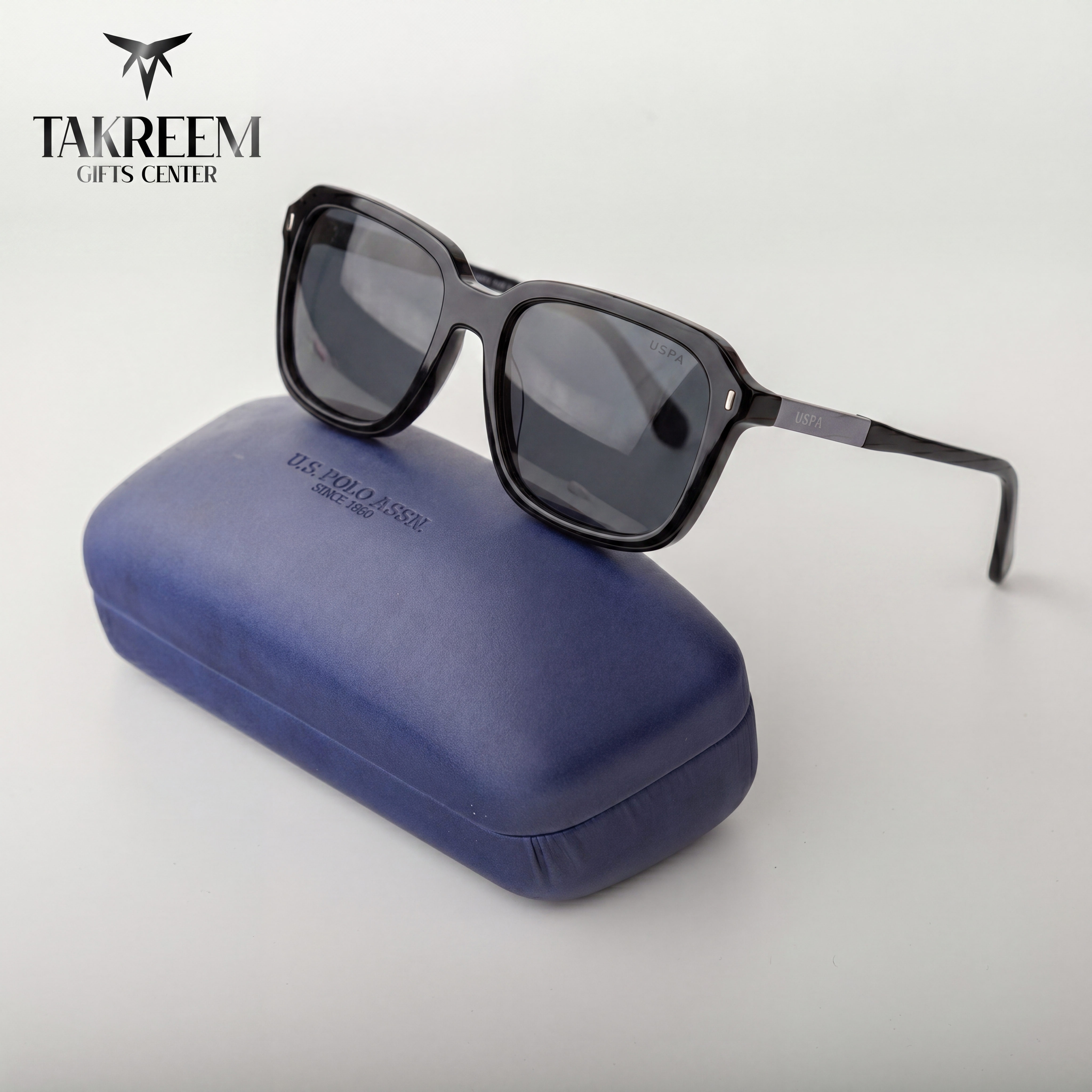 Sunglasses on a blue case with 'Takreem Gifts Center' branding.