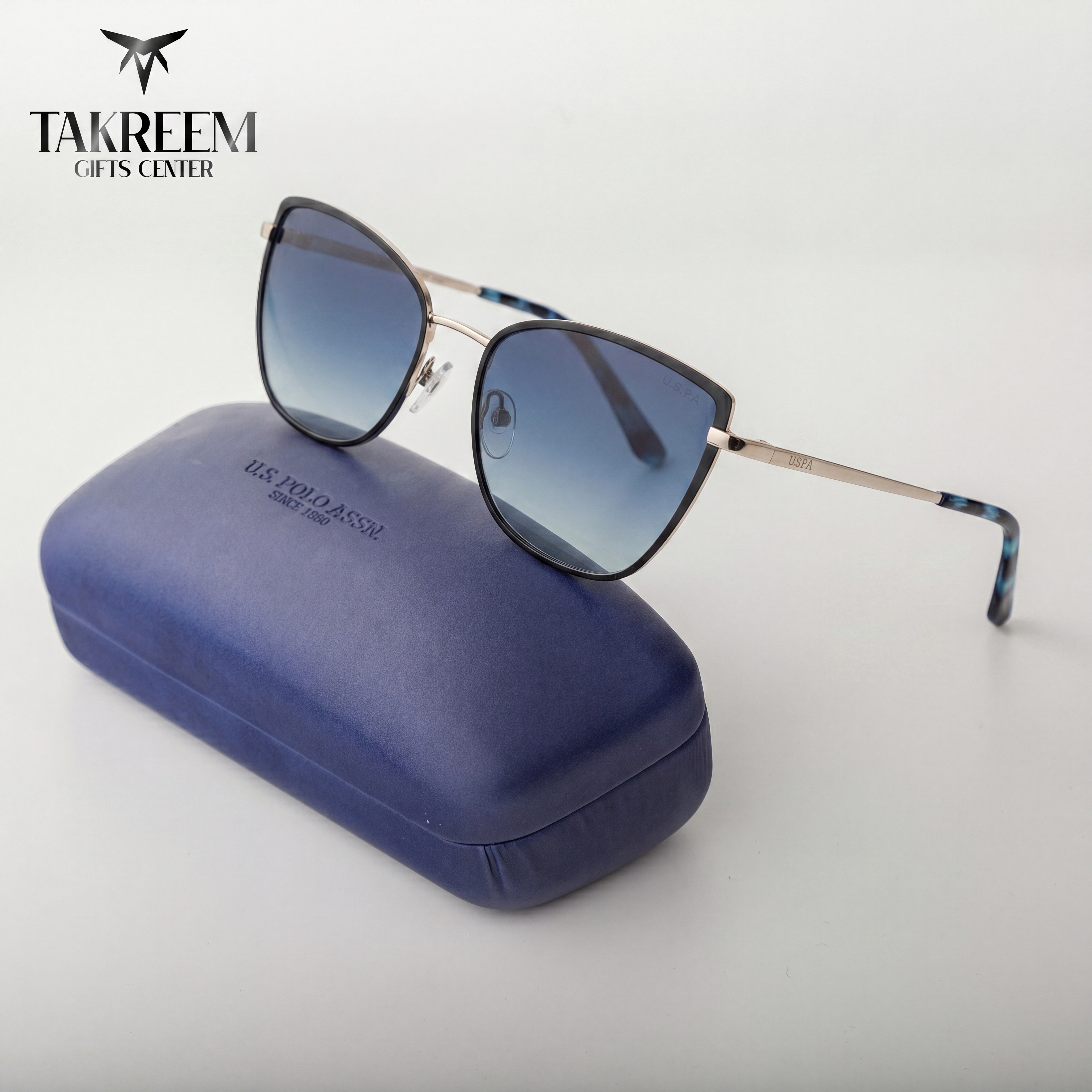 Sunglasses with a blue case on a white background, featuring the Takreem Gifts Center logo.