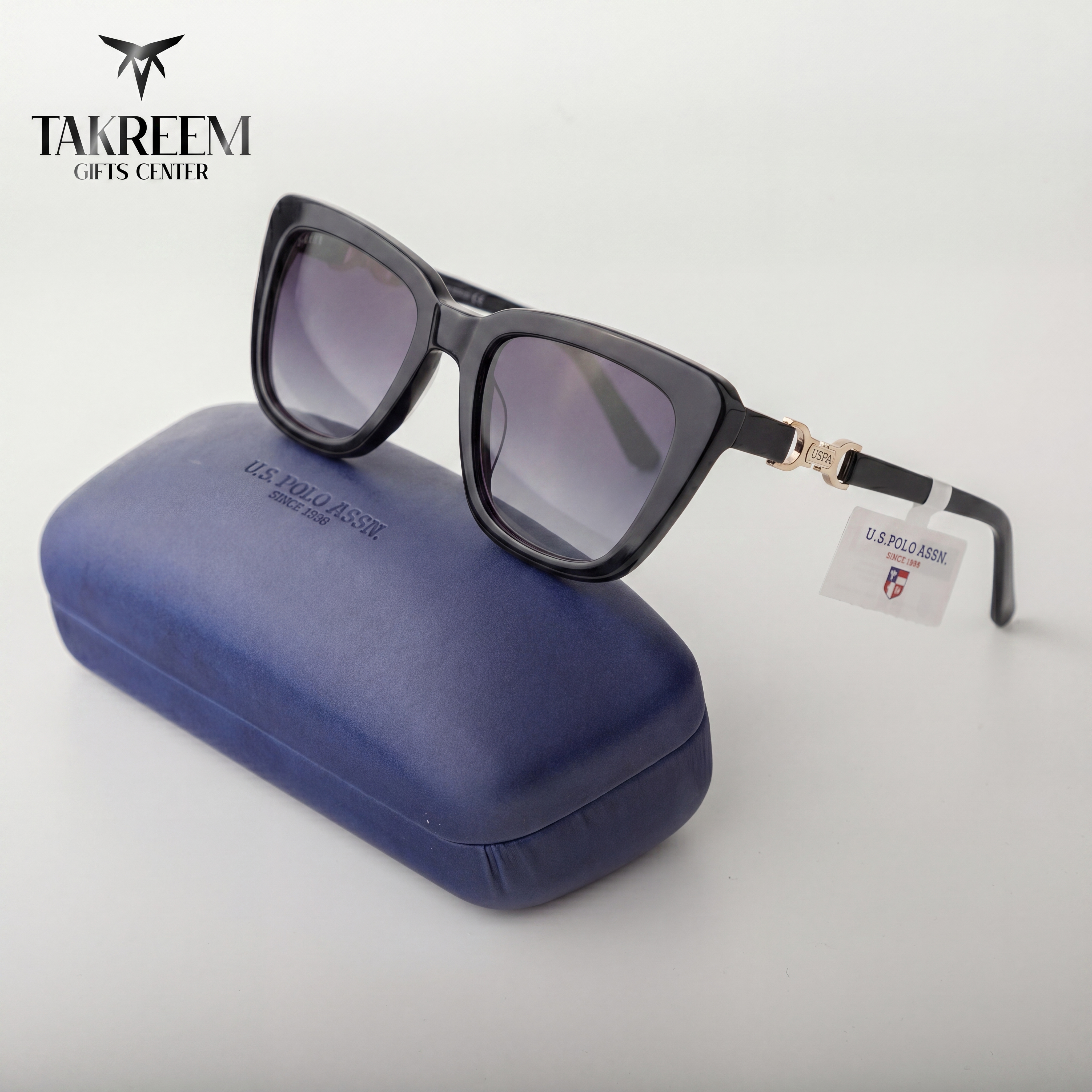 Sunglasses with a tag on a blue case, branded 'Takreem Gifts Center'.