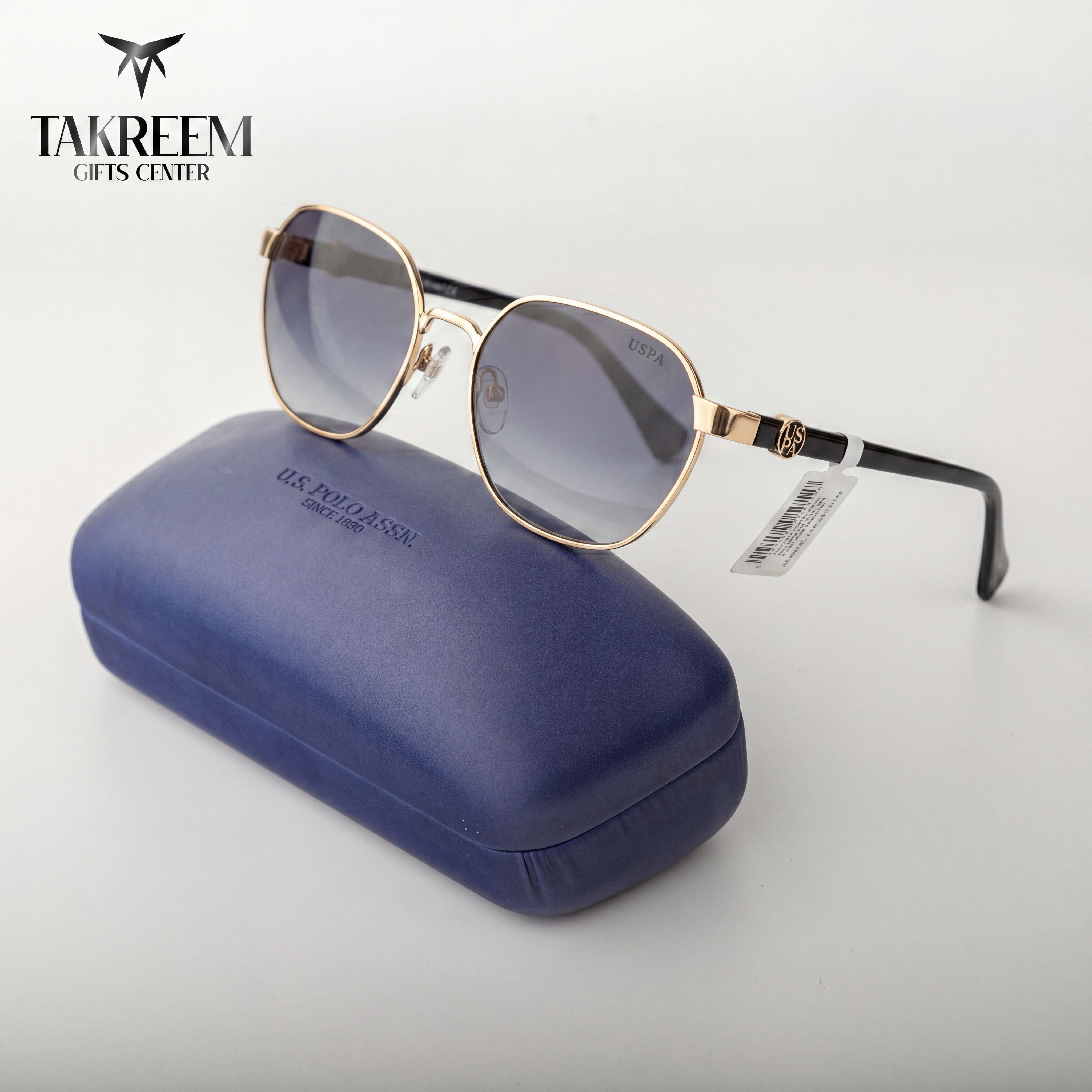 Sunglasses with gold frame and blue case on a white background, featuring Takreem Gifts Center branding.
