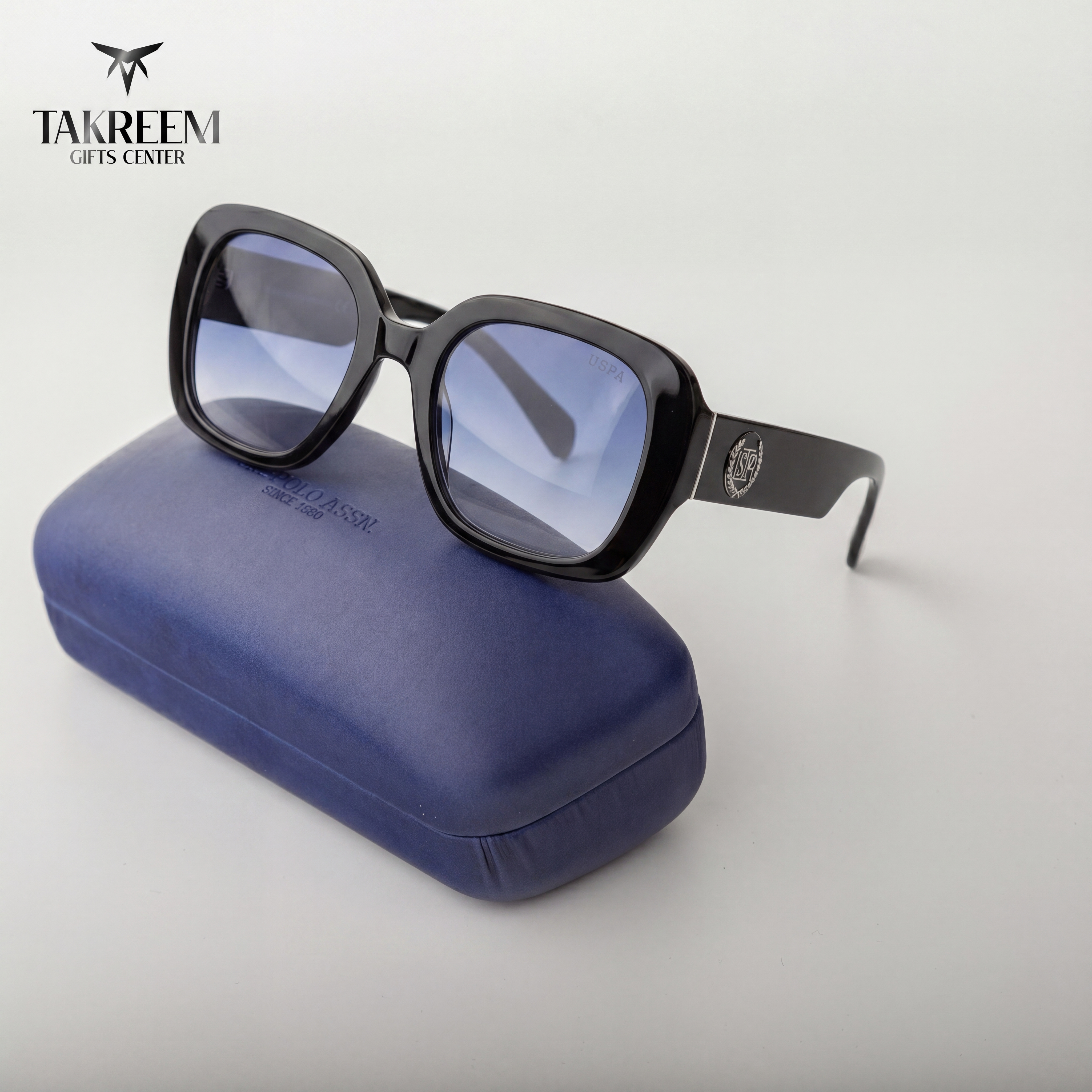 Sunglasses with blue lenses on a blue case, branded 'Takreem'.
