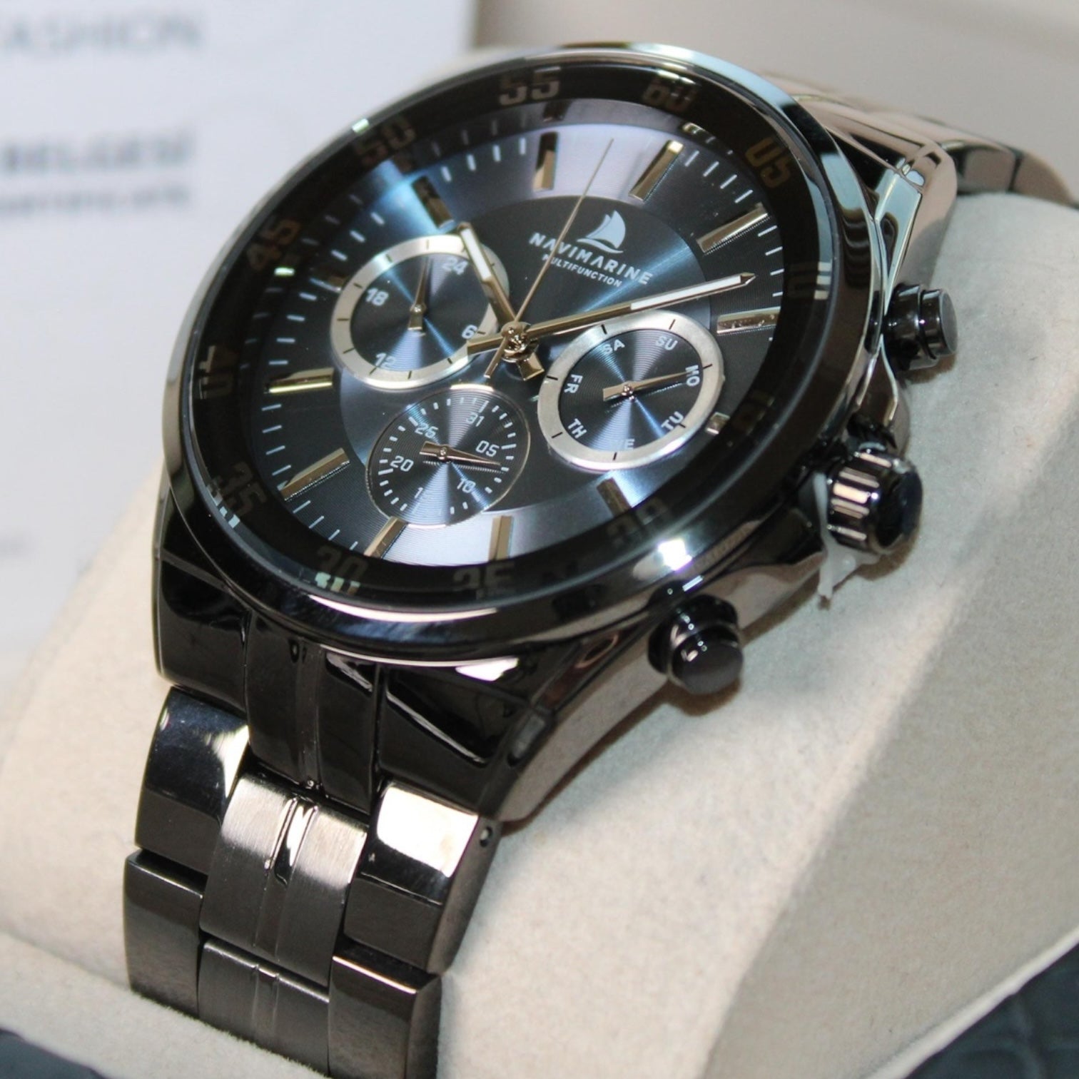 Black wristwatch with detailed face on a light background