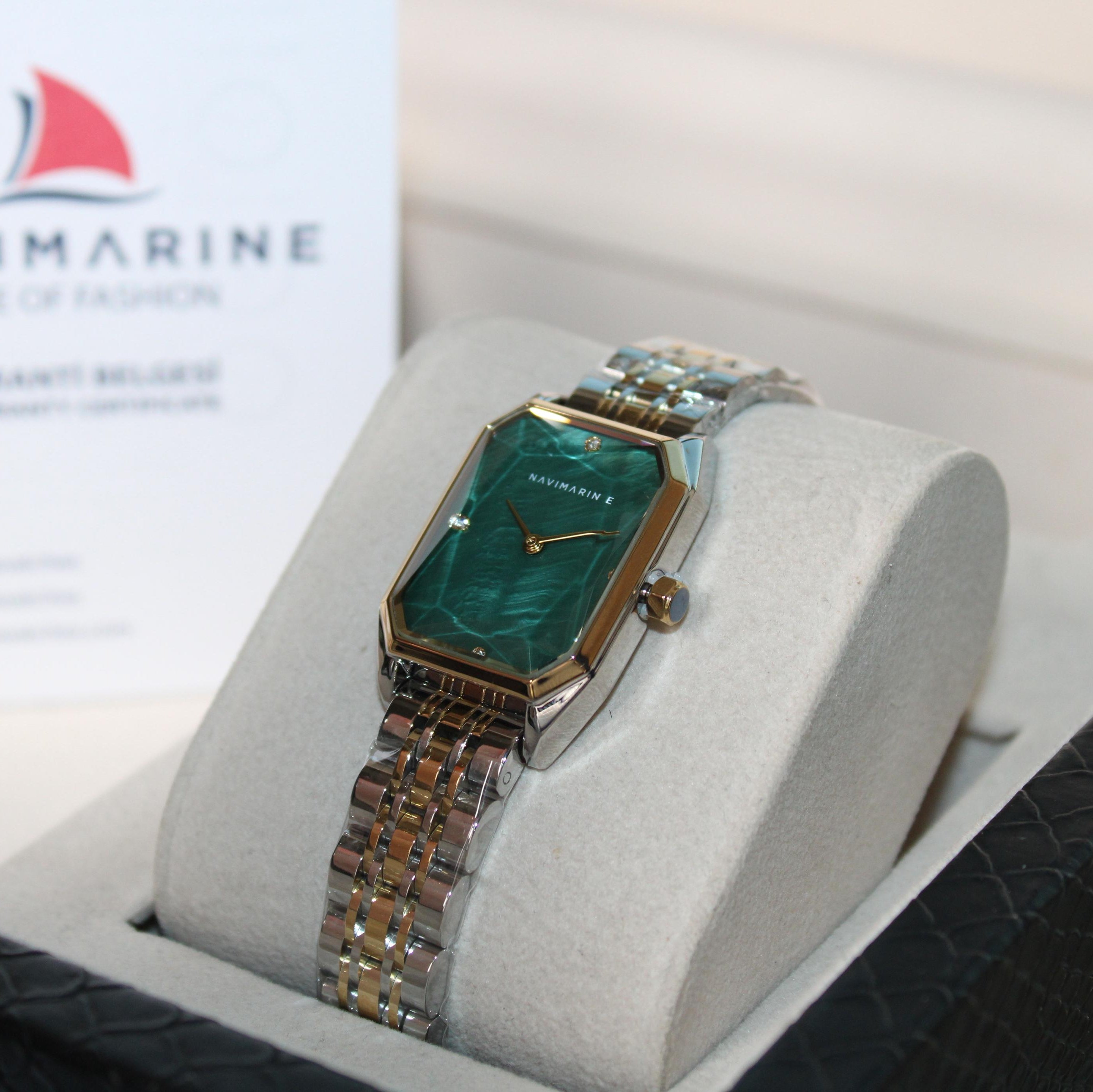 Navimarine watch in a display case with a white background