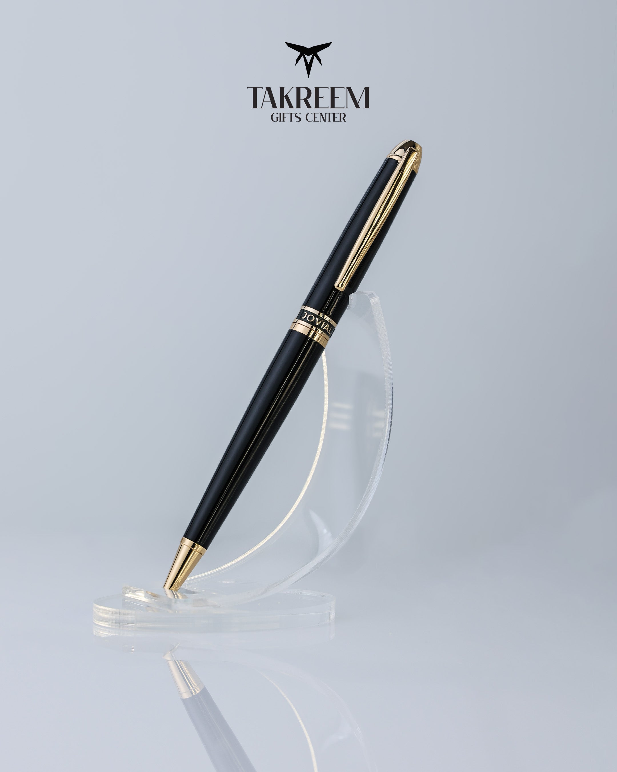 Black and gold pen on a clear stand with 'Takreem Gifts Center' branding.
