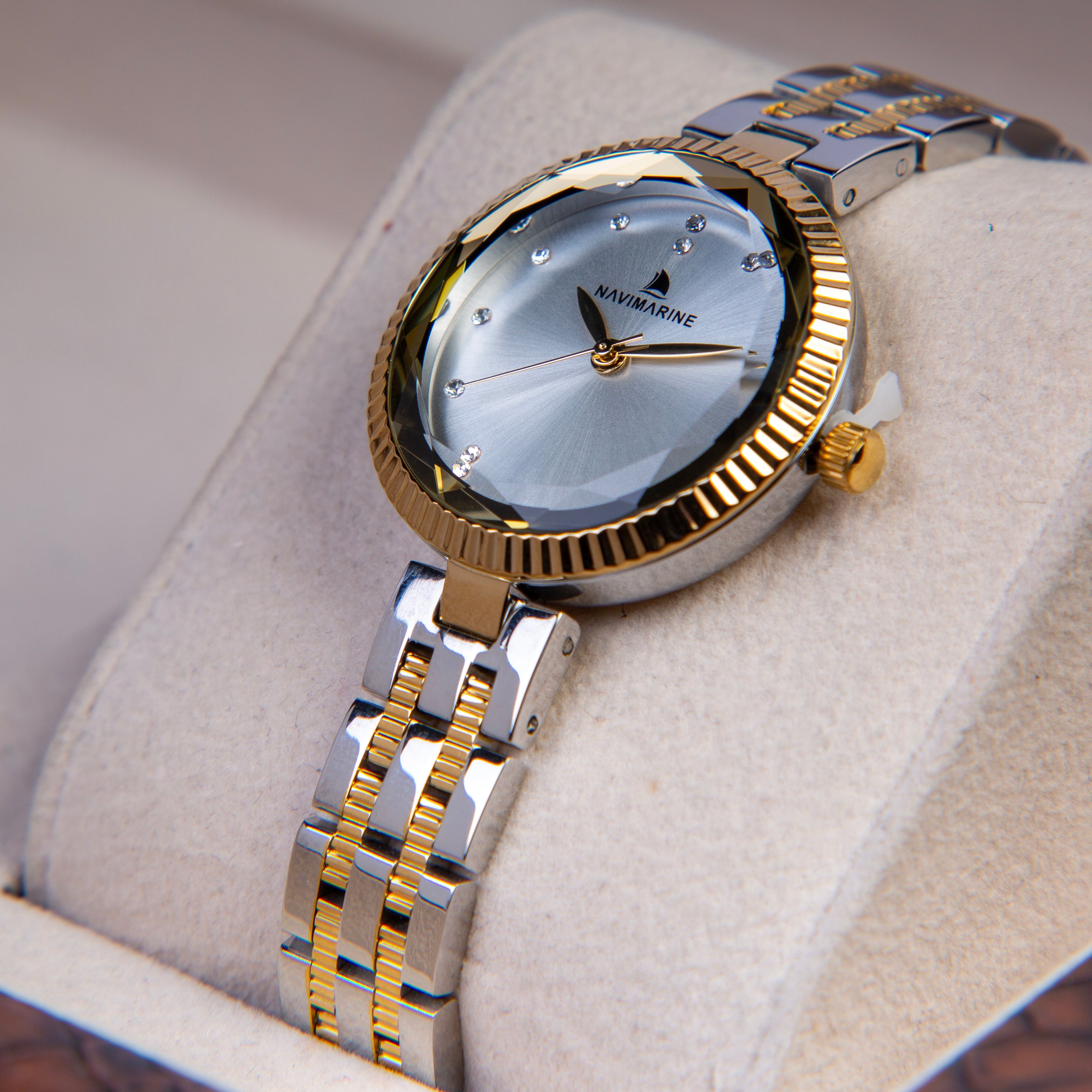 Gold and silver watch on a light fabric background