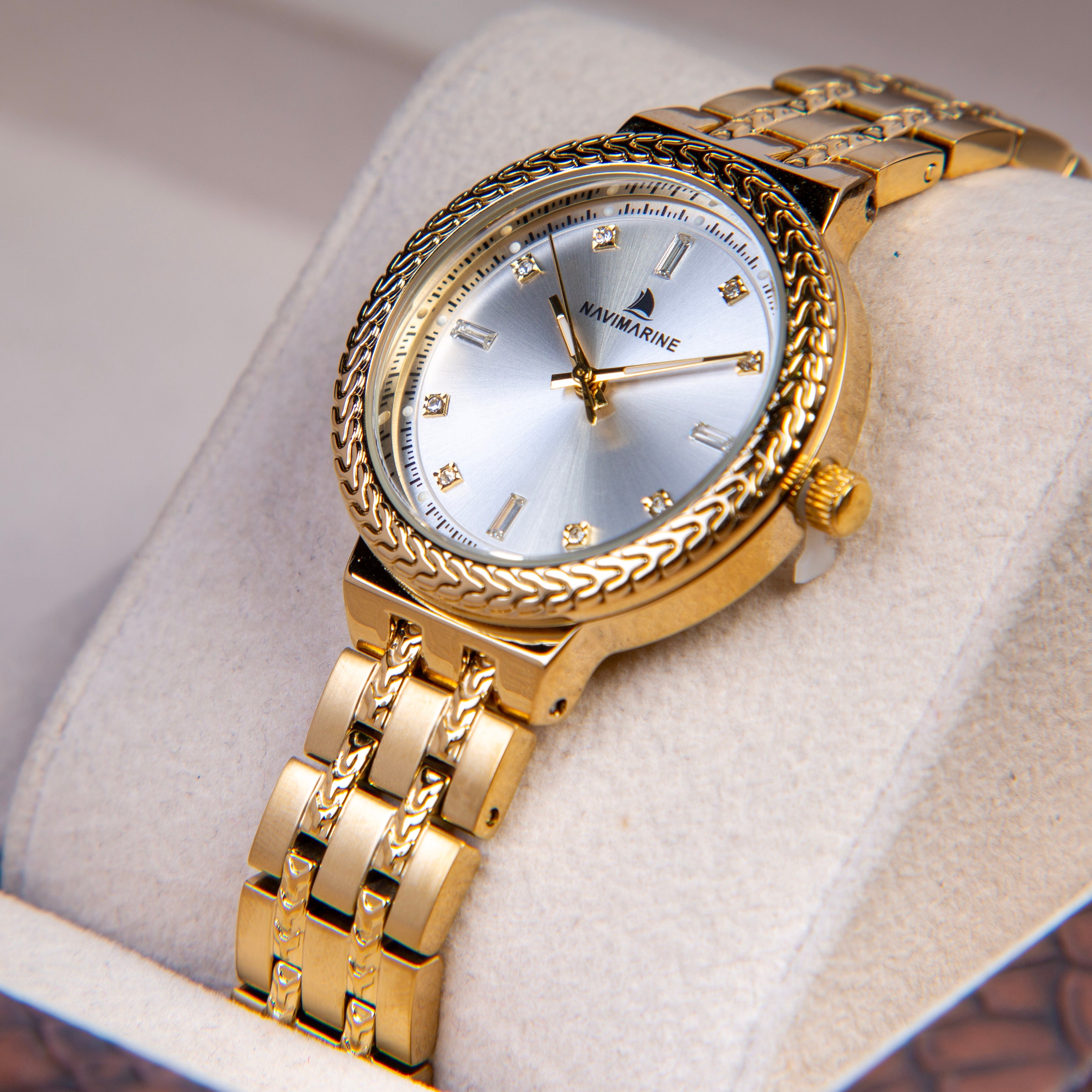 Gold wristwatch with decorative band on a soft surface