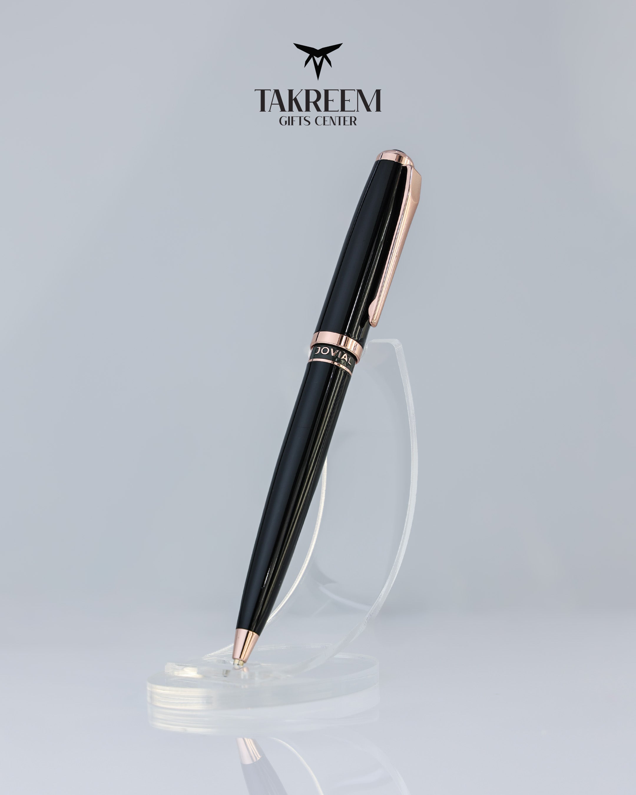 Black and rose gold pen on a clear stand with 'Takreem Gifts Center' logo above.