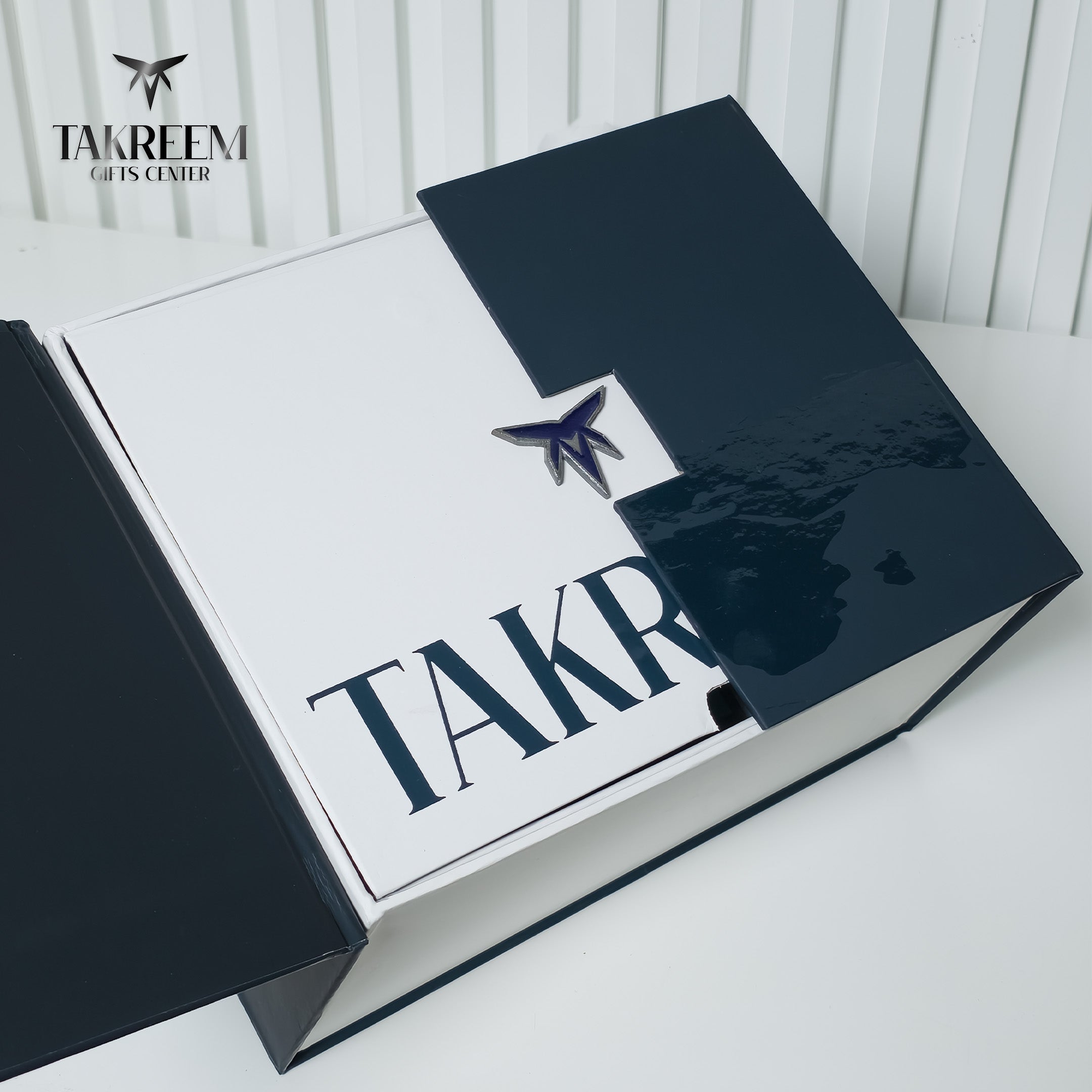 A luxury presentation box for Takreem Watches, featuring a glossy dark navy blue exterior and a white interior with the brand name 'TAKREEM' printed in navy blue. A small metallic blue star logo is visible on the lid.