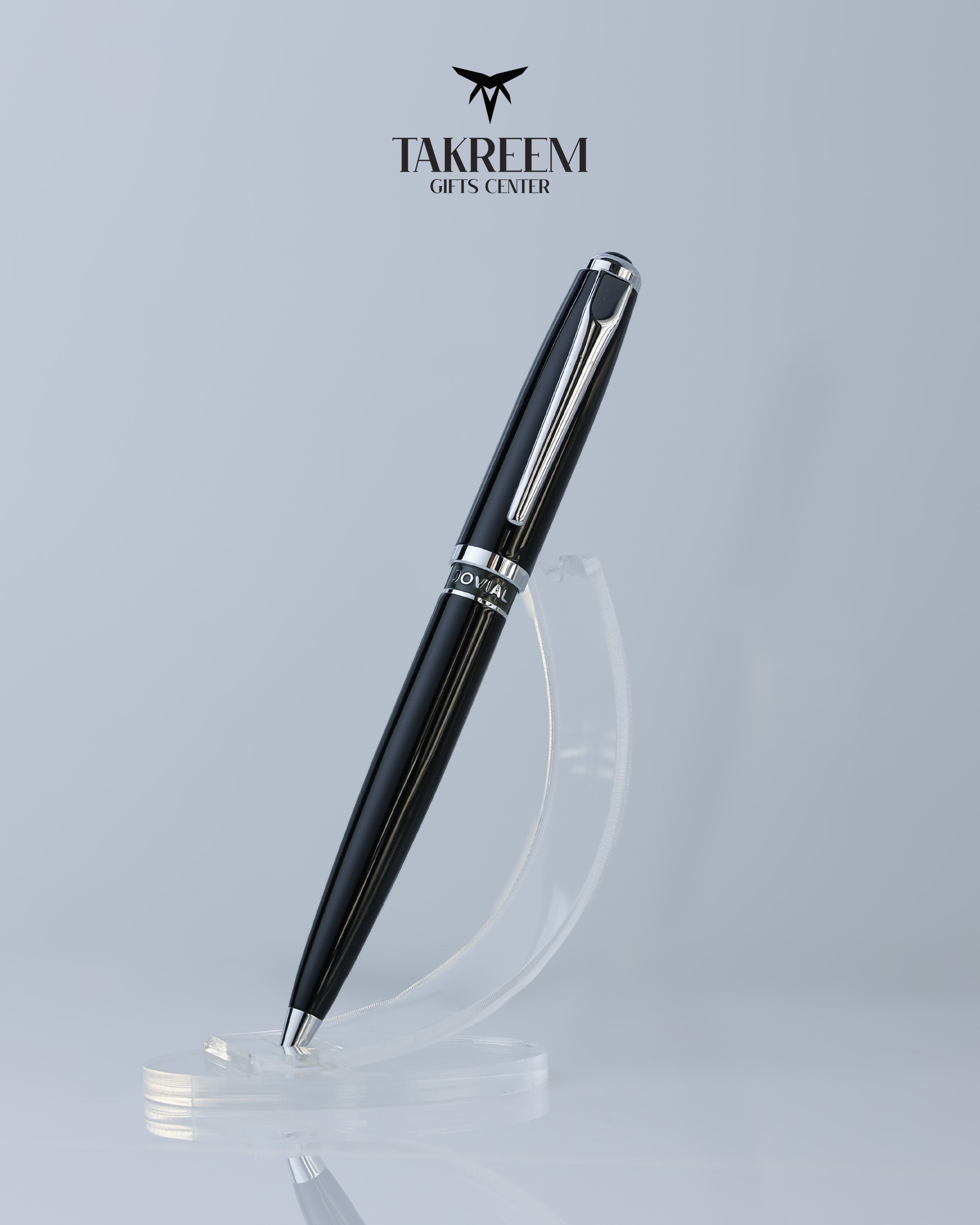 Black pen with silver accents on a clear stand against a light gray background, featuring the Takreem logo.