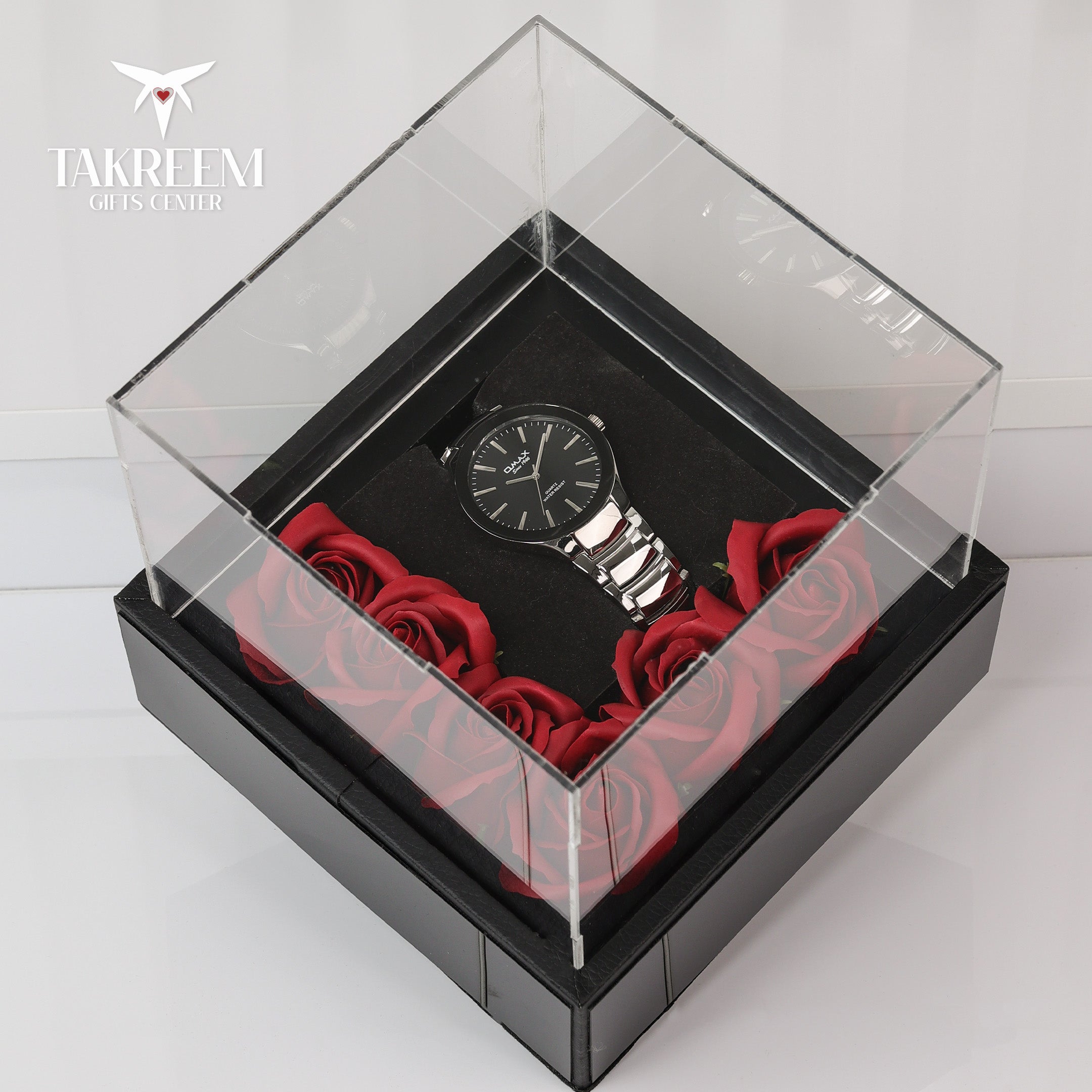 Watch in a clear box with red roses on a white background, featuring the brand 'Takreem'.