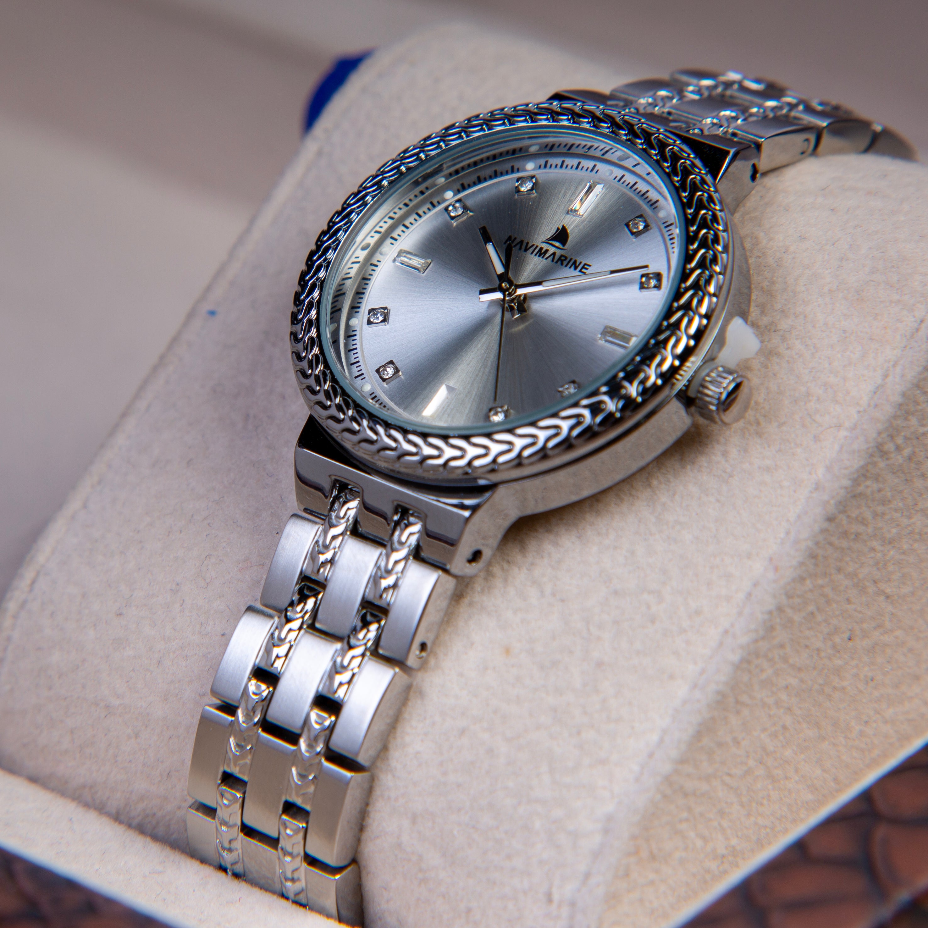 Silver wristwatch with detailed design on a soft surface