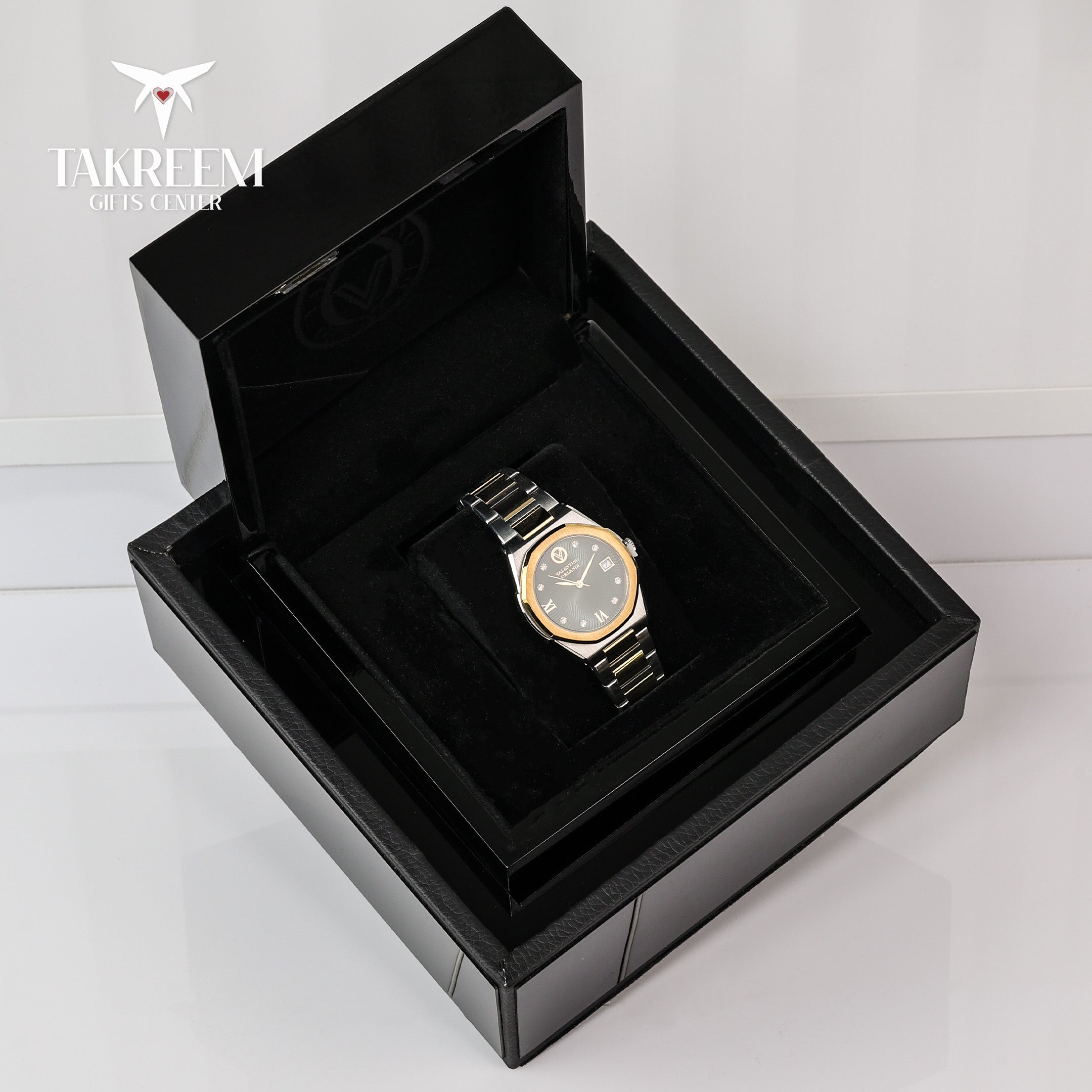 Gold watch in a black display box with 'Takreem' branding.
