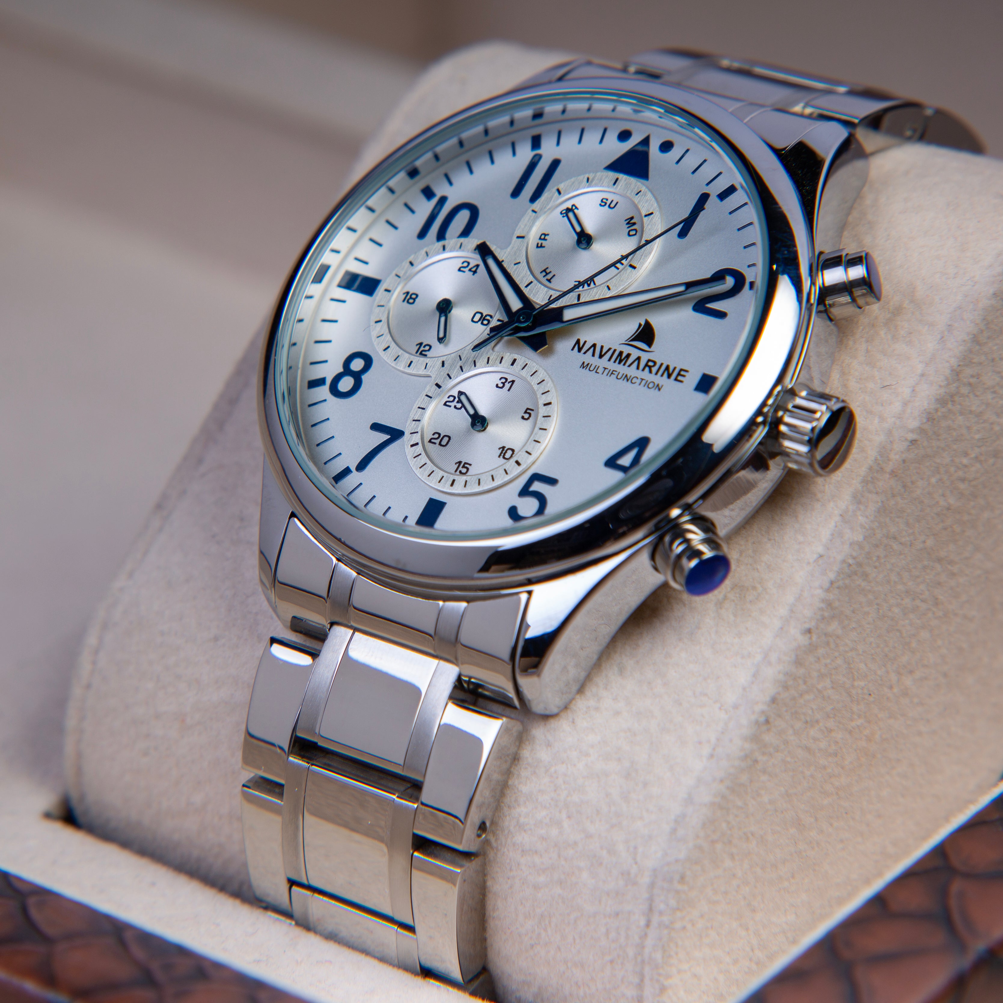 Silver Navimarine watch on a white cushion