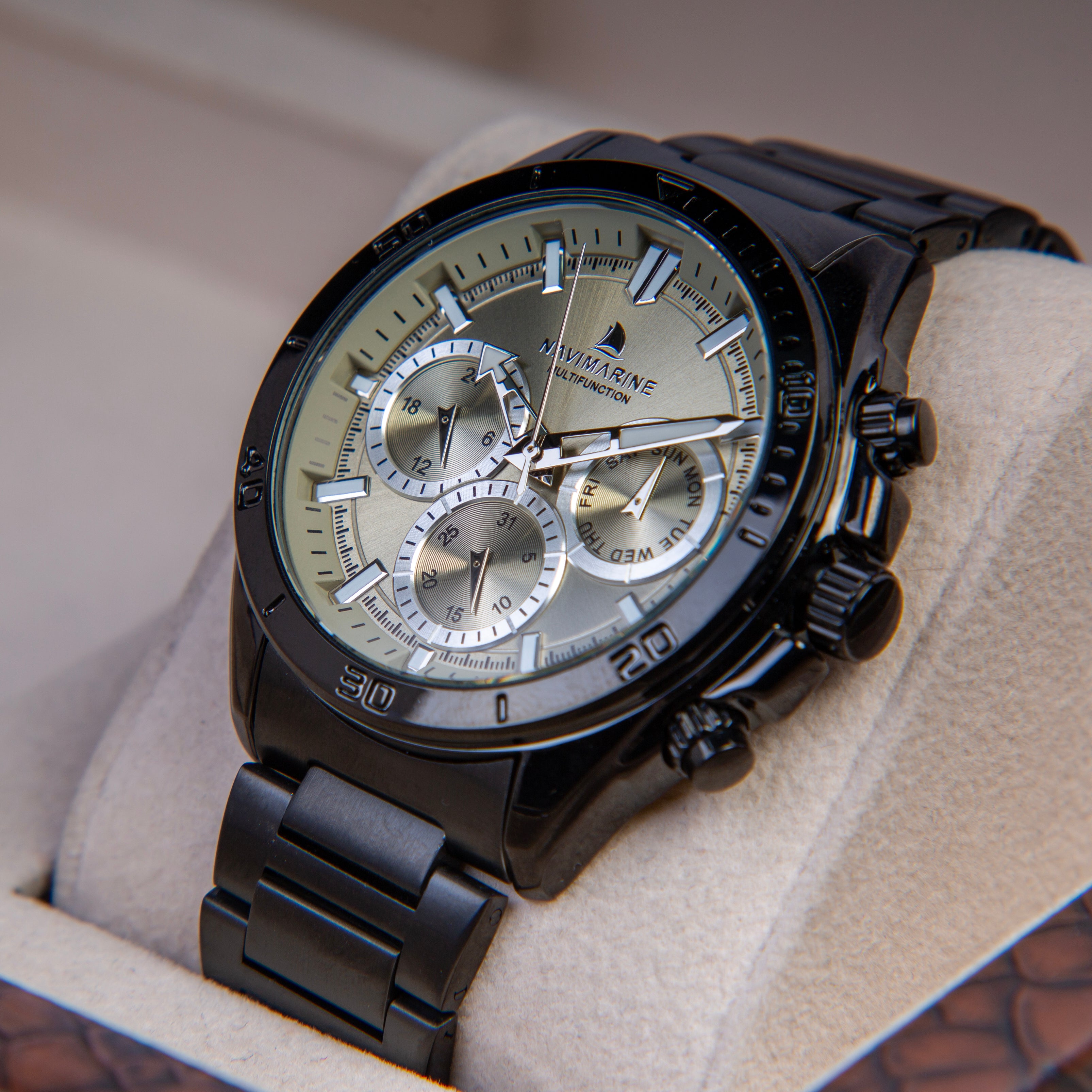 Black wristwatch with a detailed face on a textured surface