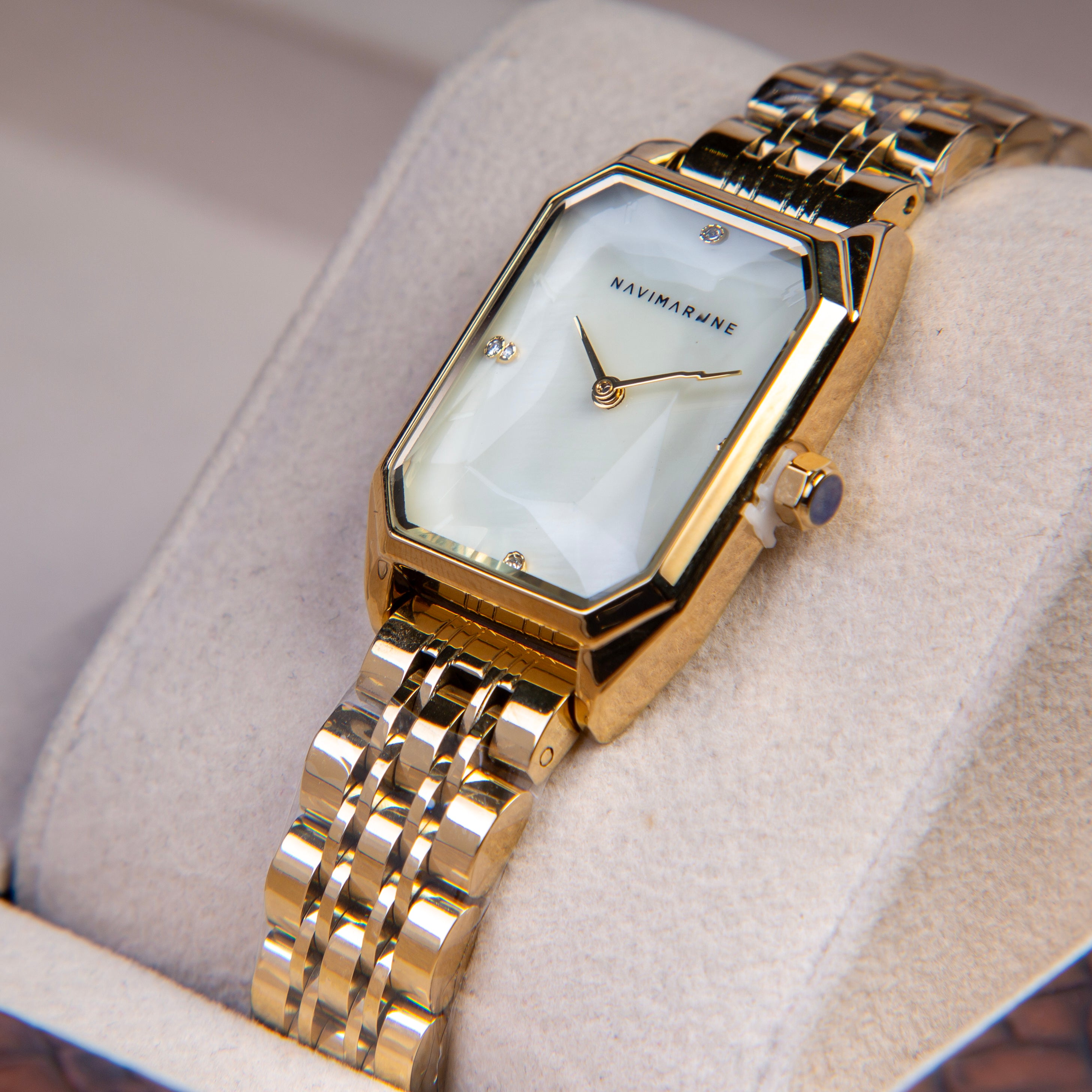 Gold wristwatch with a white face on a soft surface