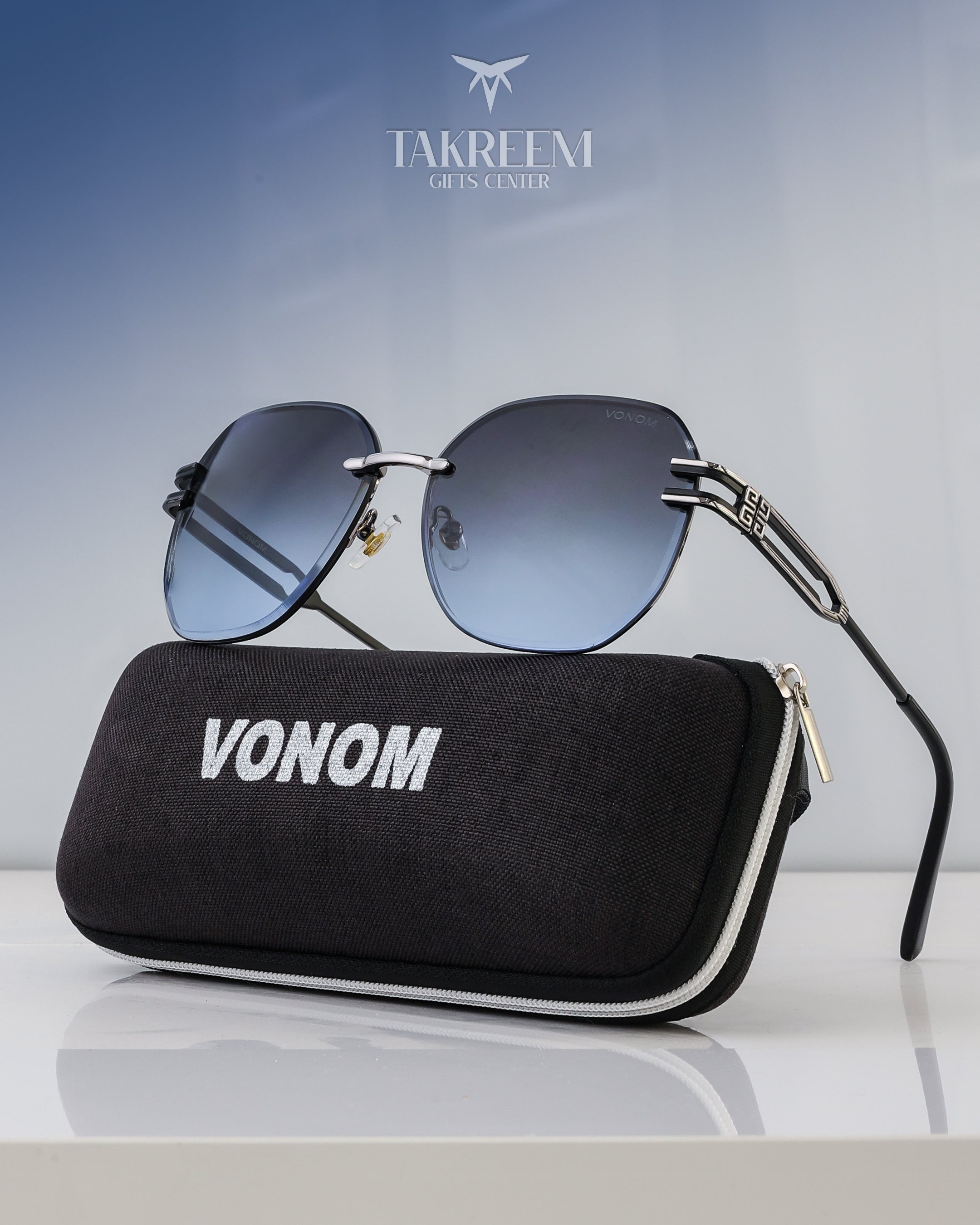 Sunglasses with a black case labeled 'VONOM' on a reflective surface, with 'Takreem' branding in the background.