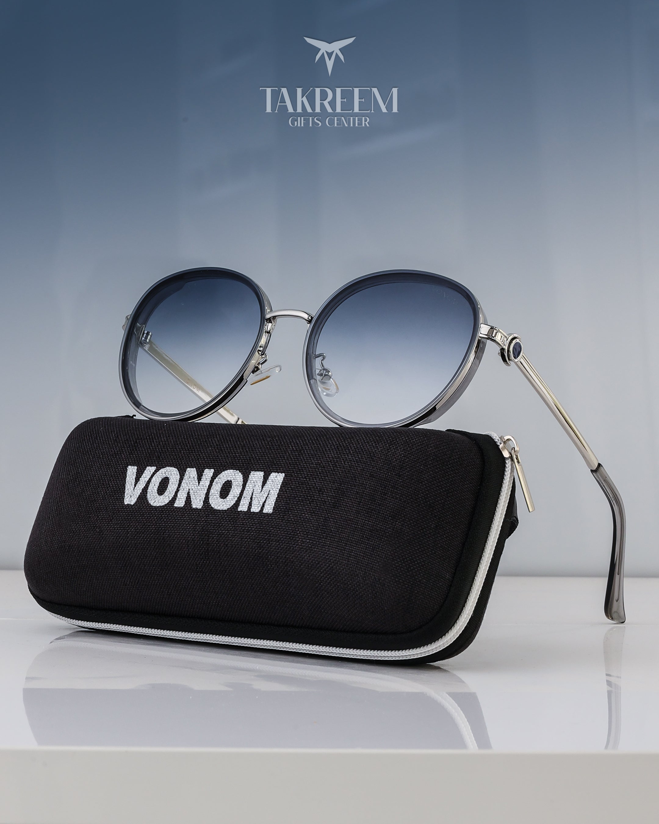 Round sunglasses with gradient lenses on a black case labeled 'VONOM' against a light gray background.