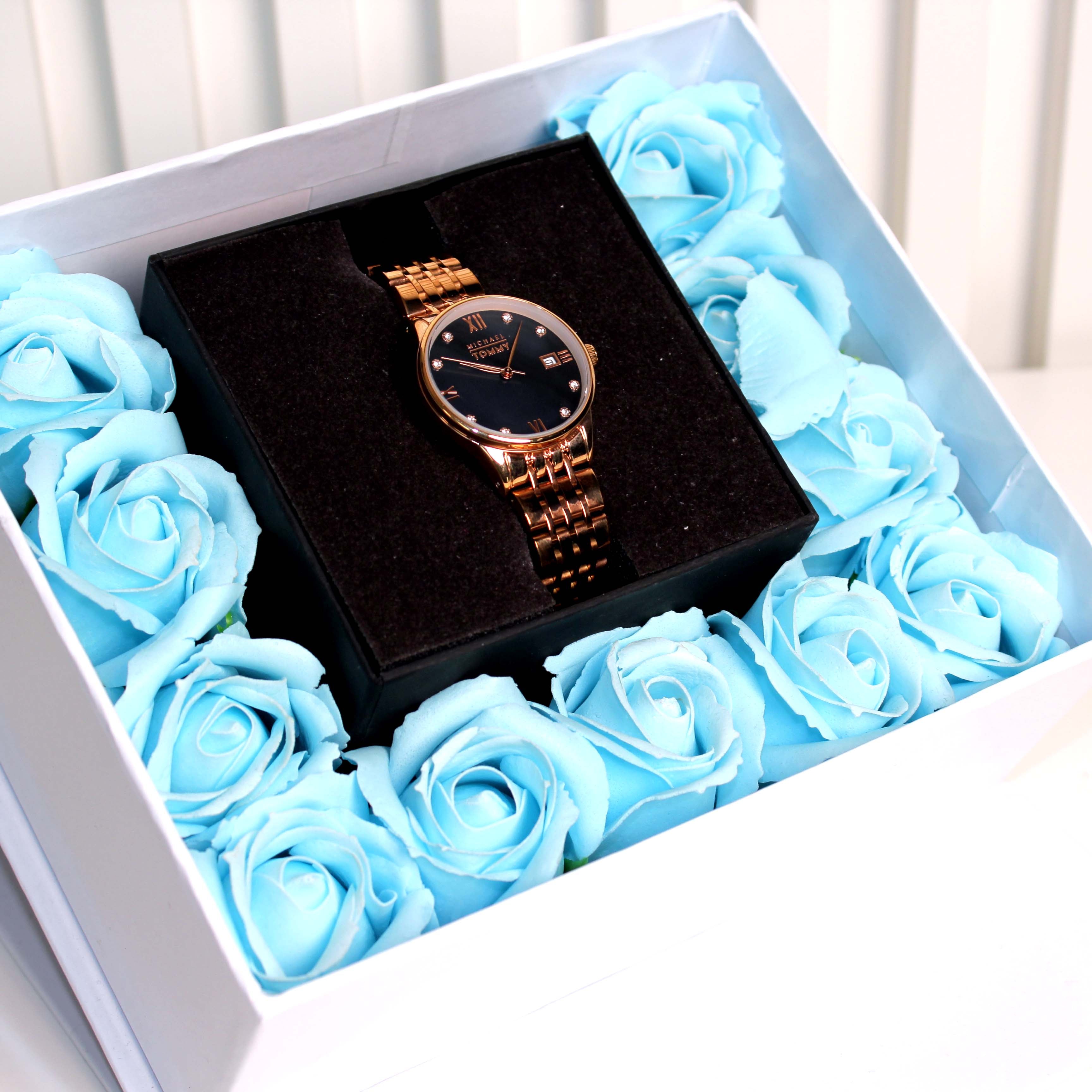 Rose gold watch in a box with blue roses