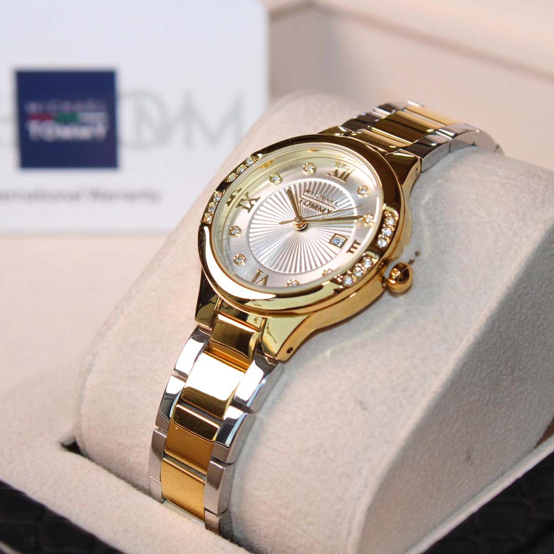 Gold wristwatch on a white cushion with a blurred background