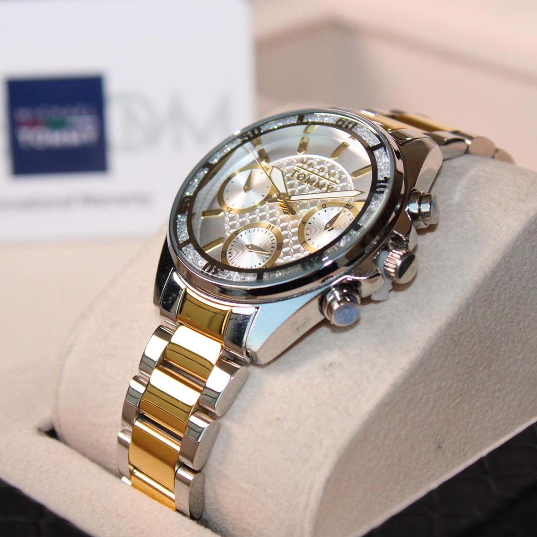 Luxury watch with gold and silver band on a white cushion