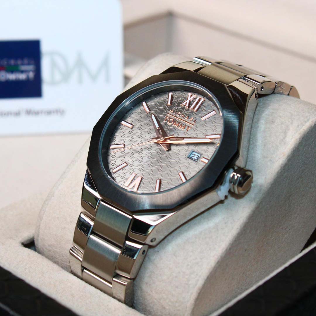 Silver watch with a detailed face on a white cushion, brand name visible