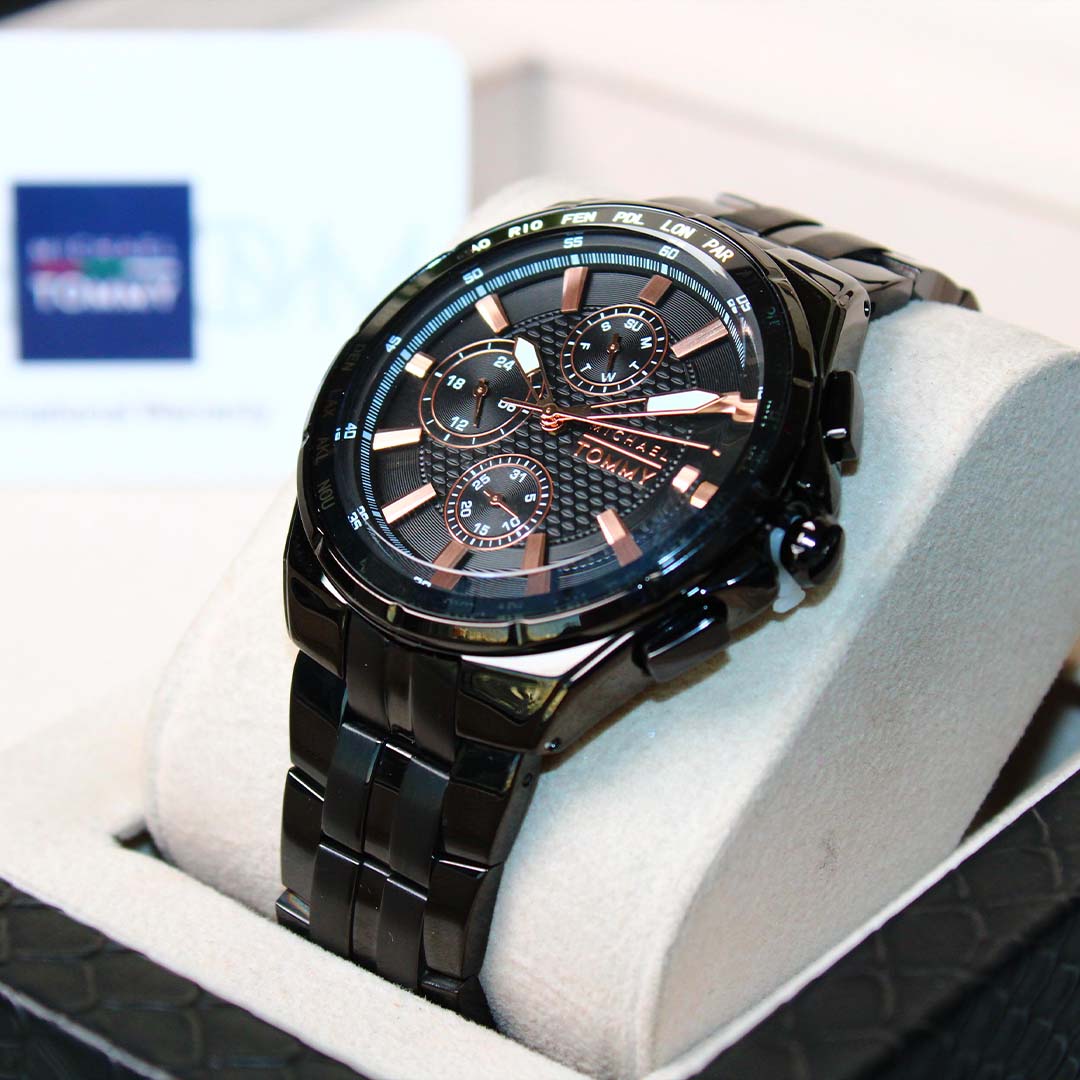 Black wristwatch with detailed face on a white cushion, brand logo visible