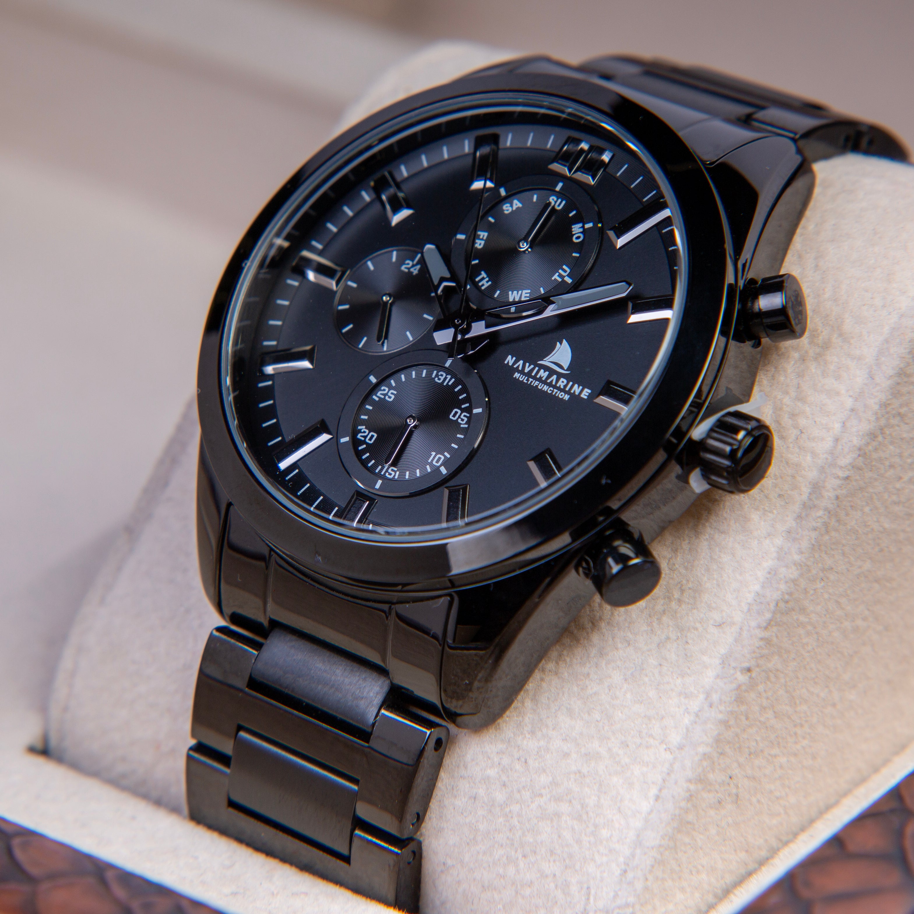 Black wristwatch with detailed face on a textured surface
