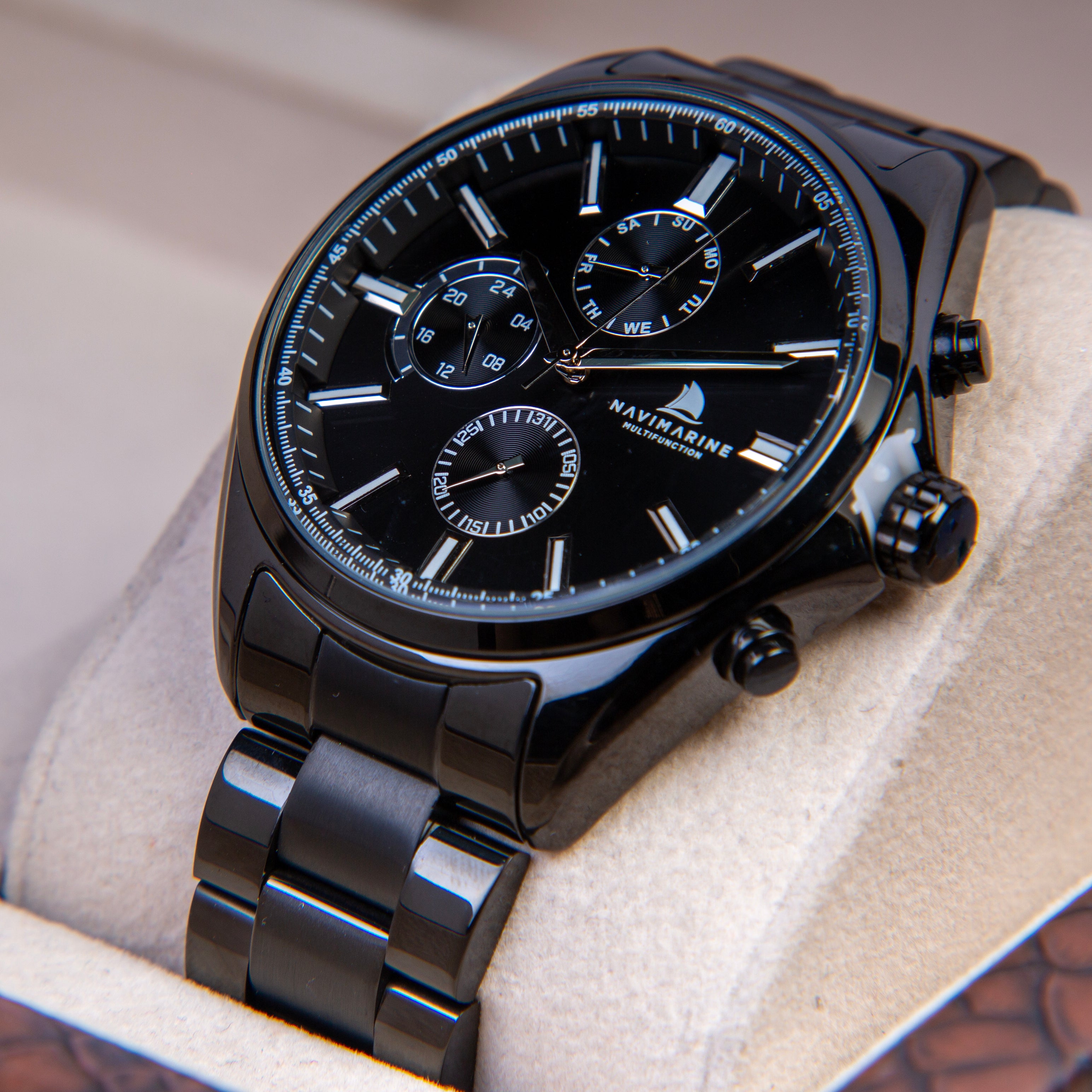 Black wristwatch with detailed face on a textured surface