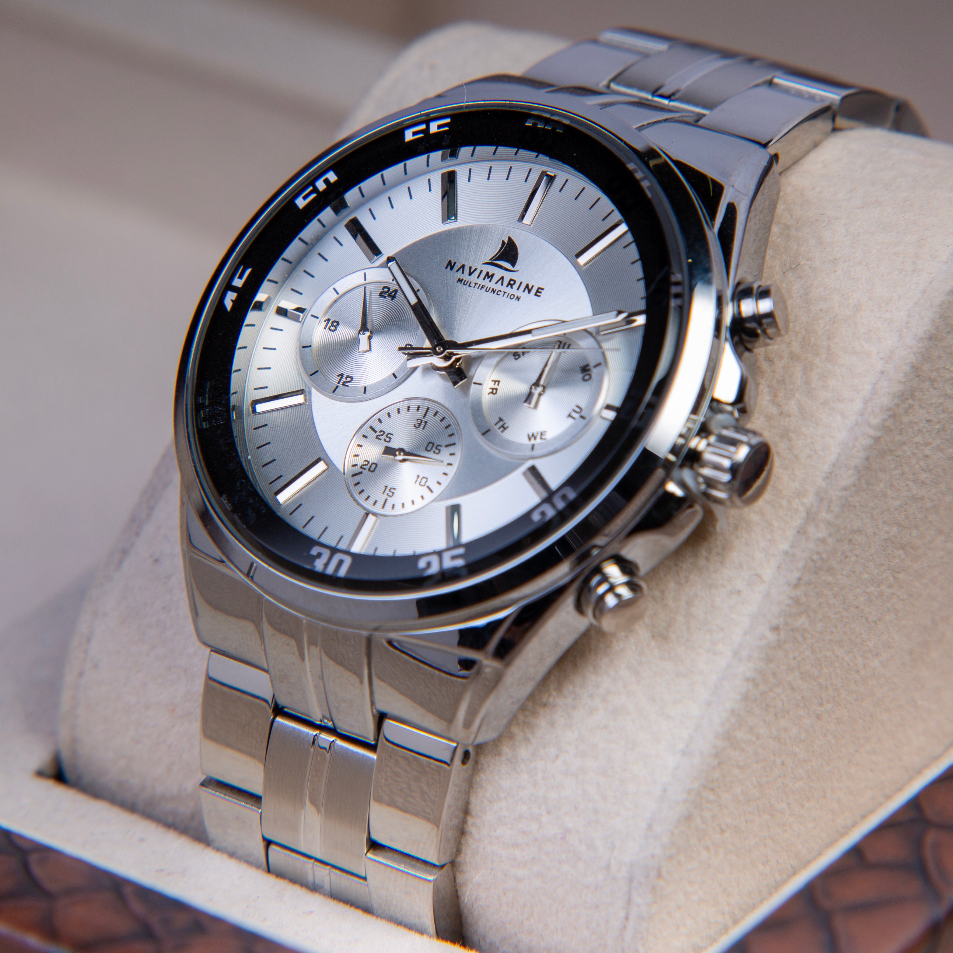 Silver wristwatch with detailed face on a soft surface