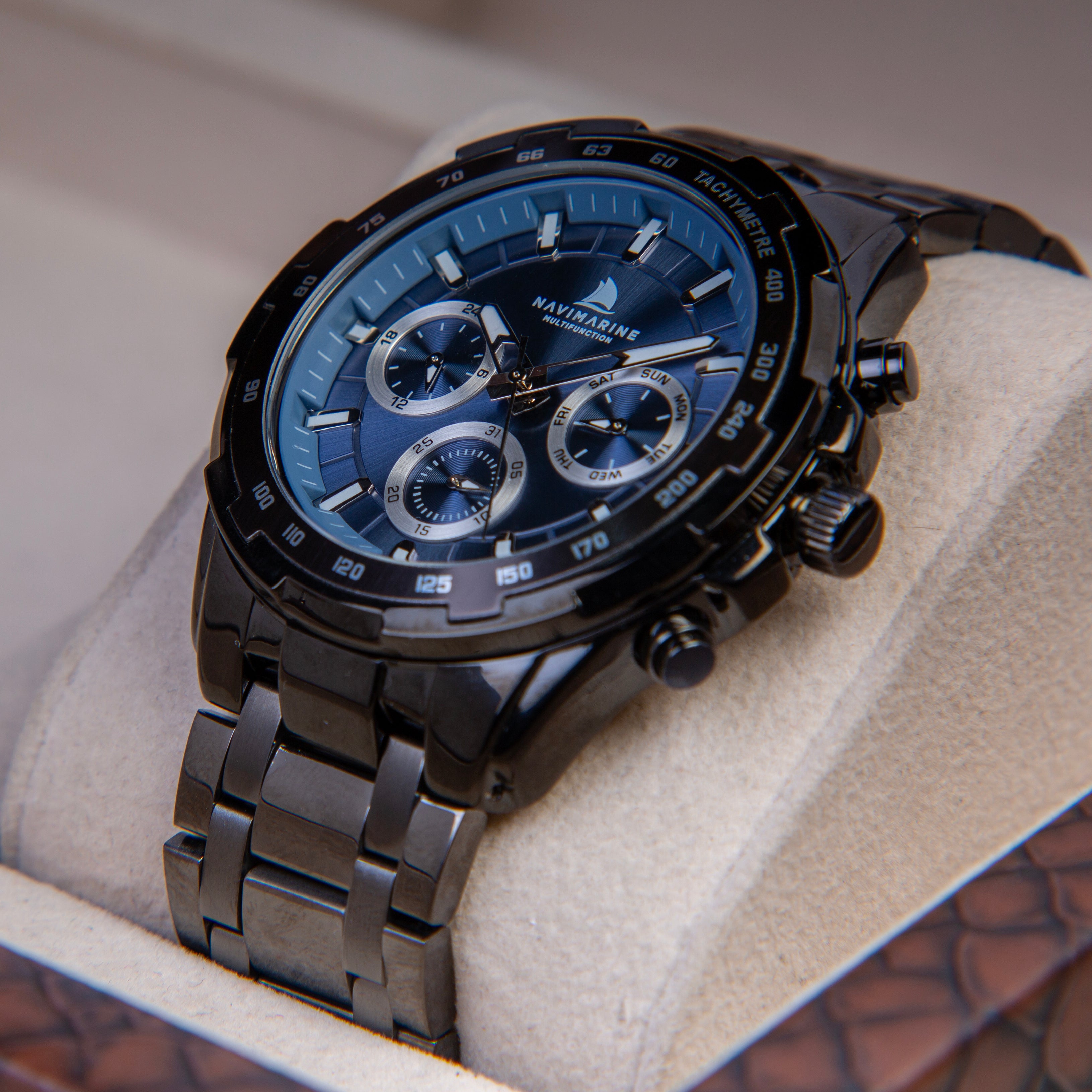 Luxury watch with blue face and black strap in a box