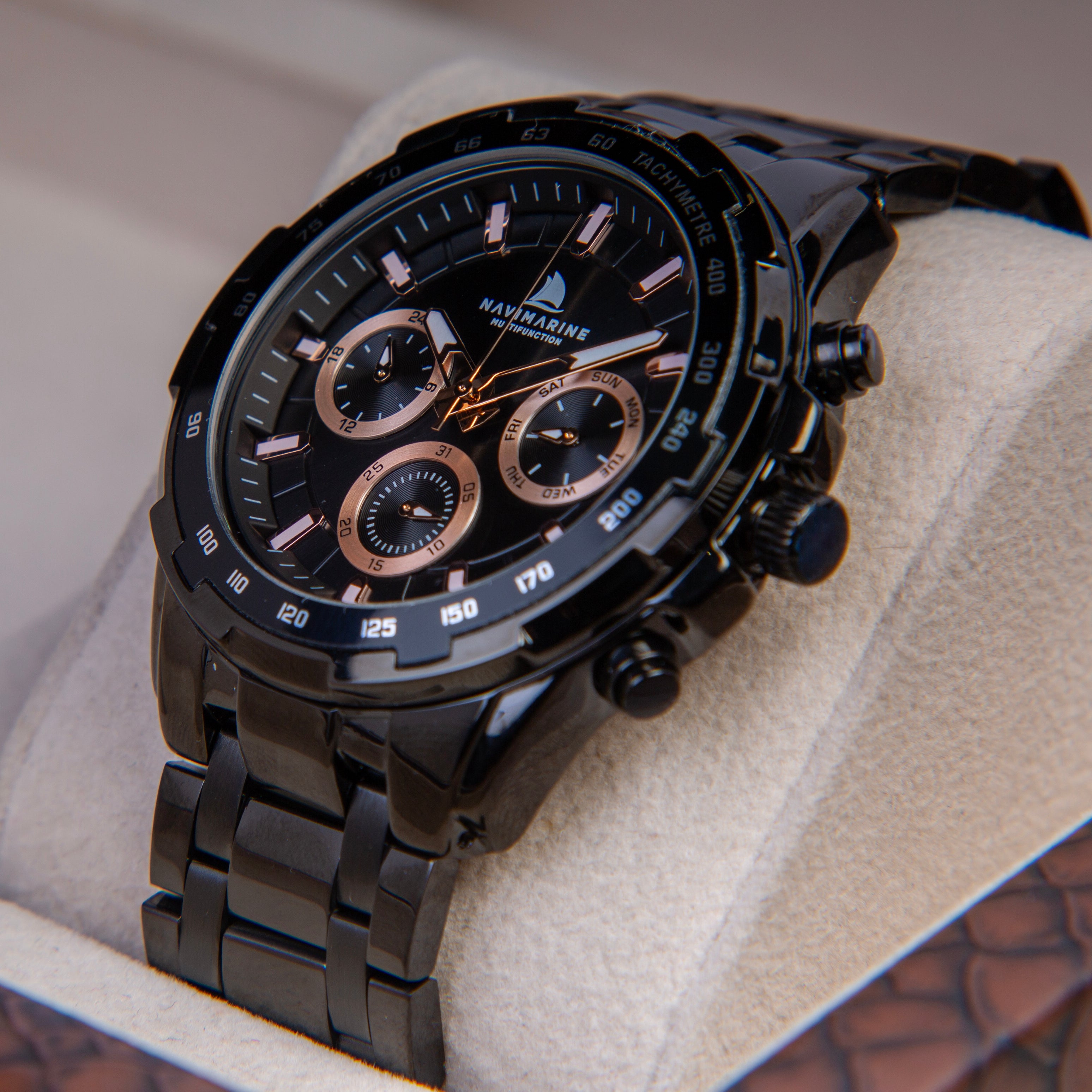 Black wristwatch with detailed face on a textured surface