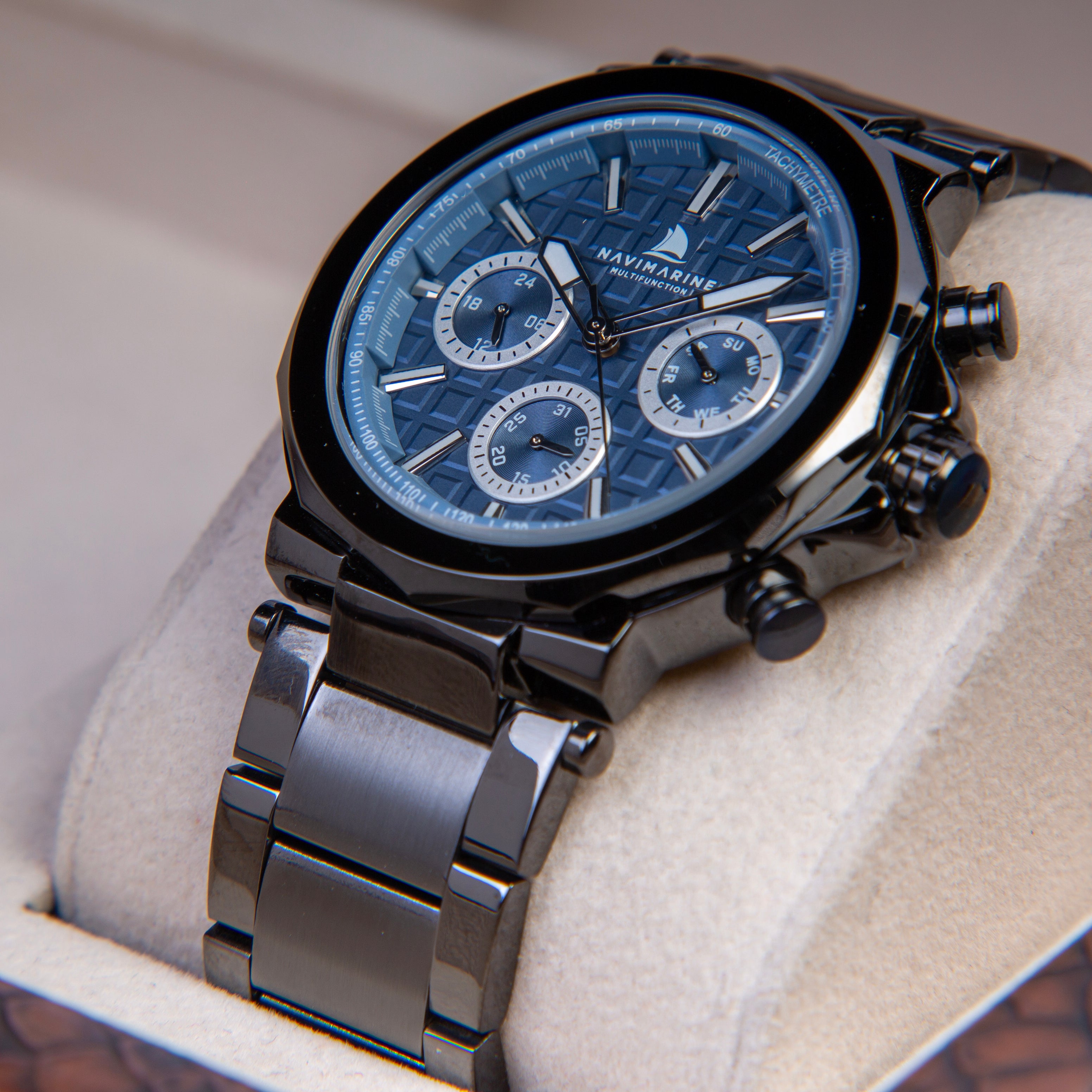 Luxury watch with black strap and blue face on a light background