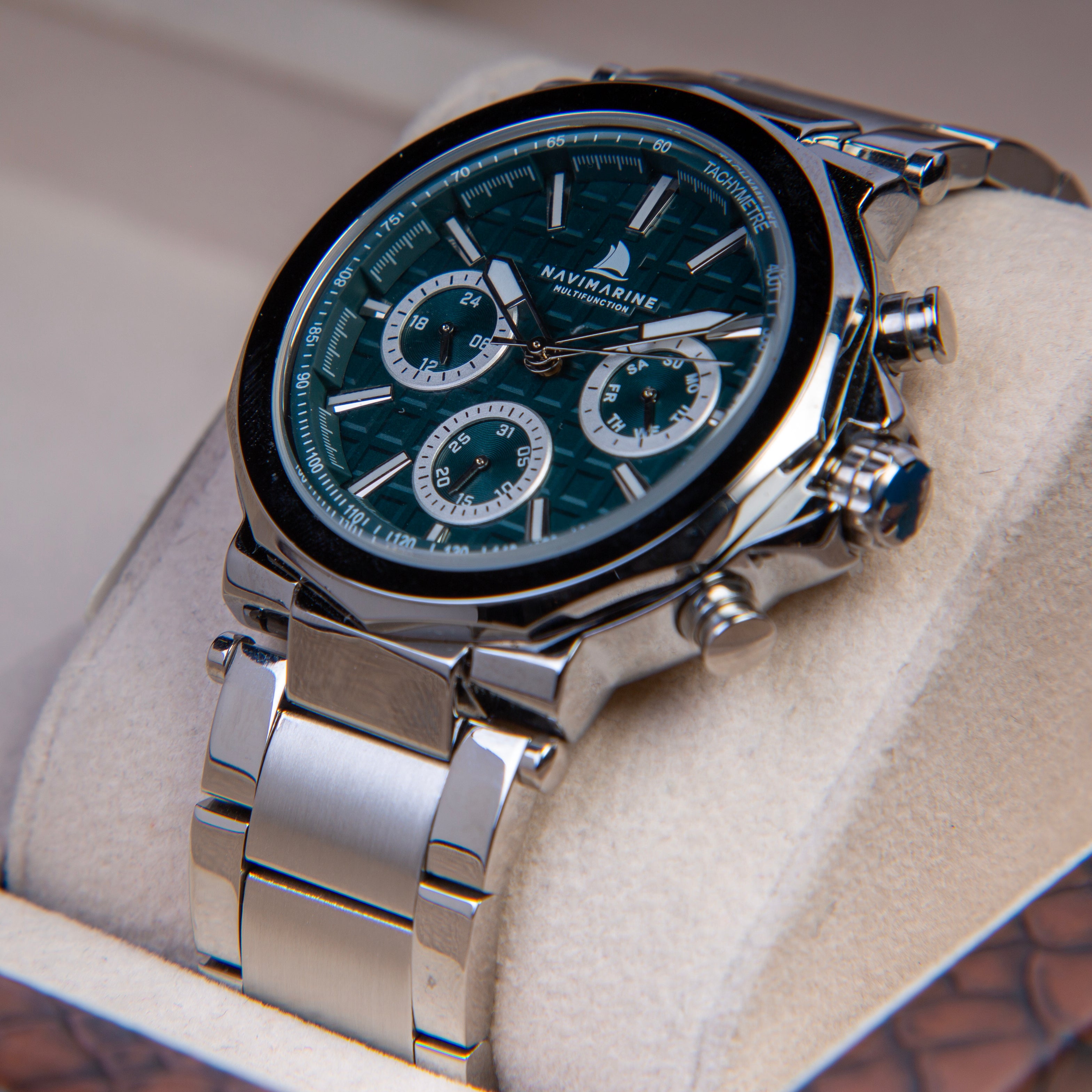 Silver wristwatch with a detailed face on a beige cushion